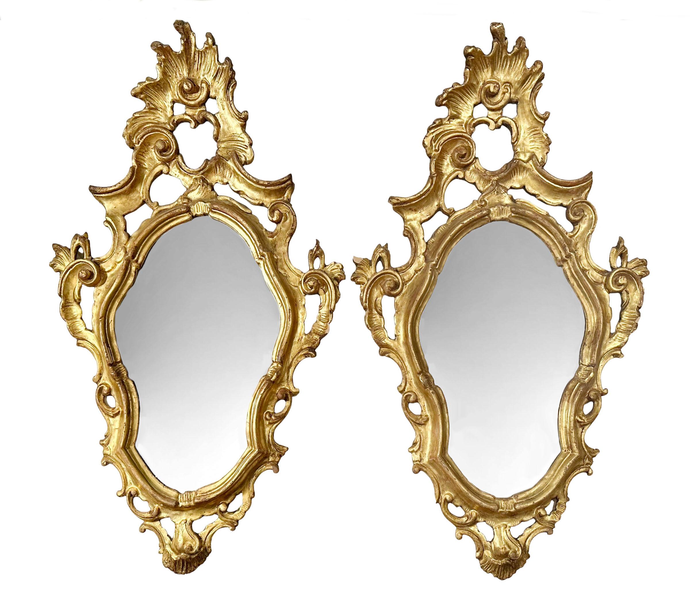 A pair of 19th century Italian mirrors in the rococo style with original glass. Gold gilded on carved wood, in amazing condition. 