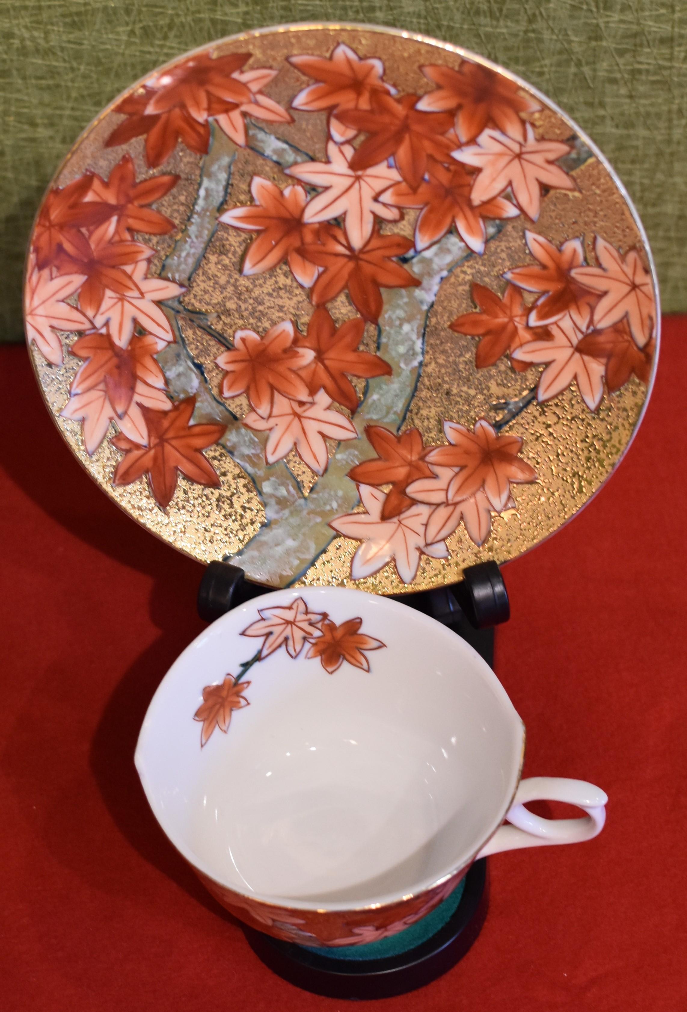 Unique contemporary gilded fine porcelain cup and saucer, intricately hand-painted in iron-red and peach on an attractive gilded body, featuring autumn maple leaves.
This cup and saucer is from a signature series by a highly acclaimed award-winning