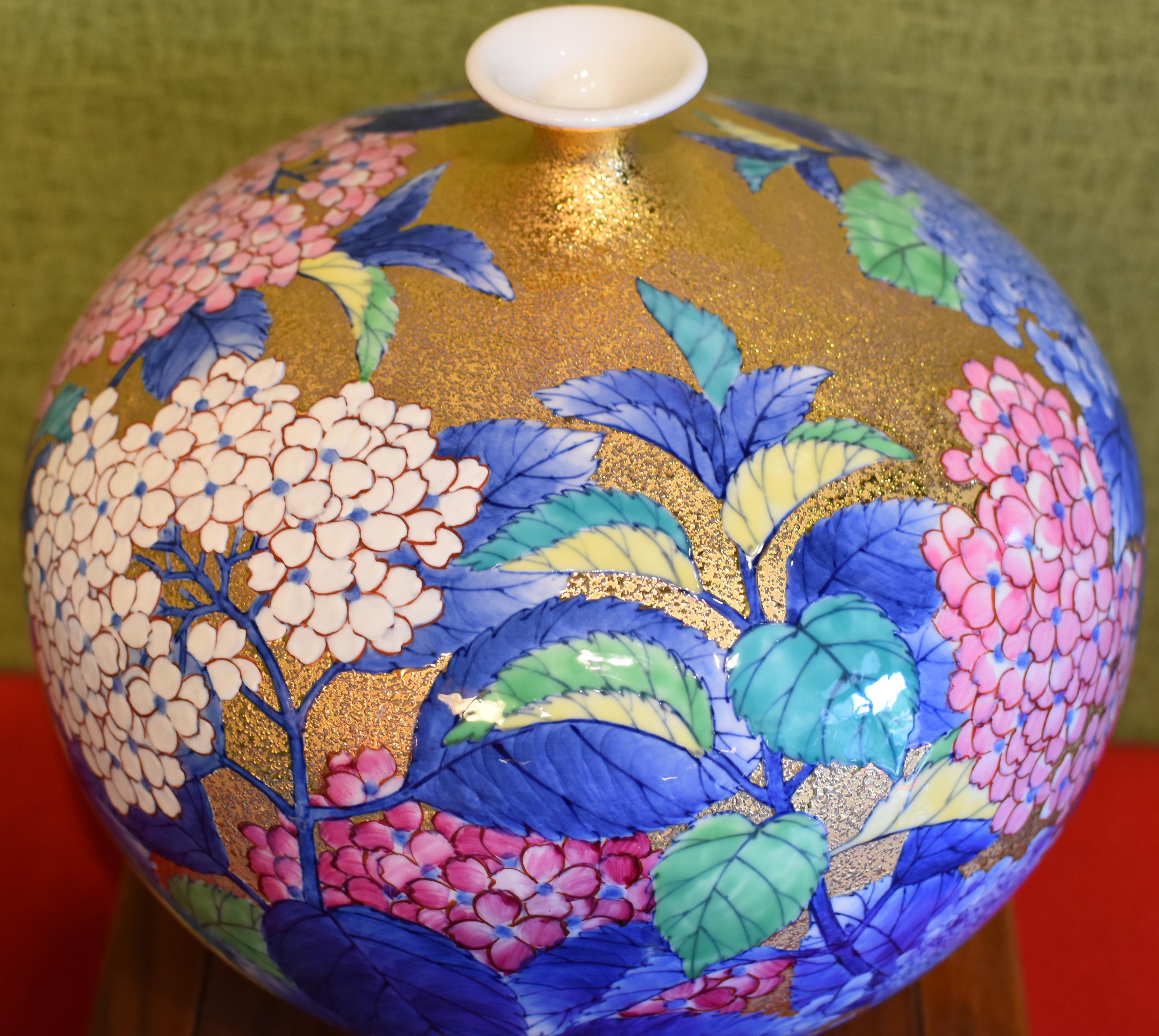 Striking contemporary Imari gilded porcelain vase, hand-painted in pink, red and white on an attractive gilded ovoid shape body. This piece is a work of highly respected award-winning master porcelain artist from Imari-Arita region of Japan.
This