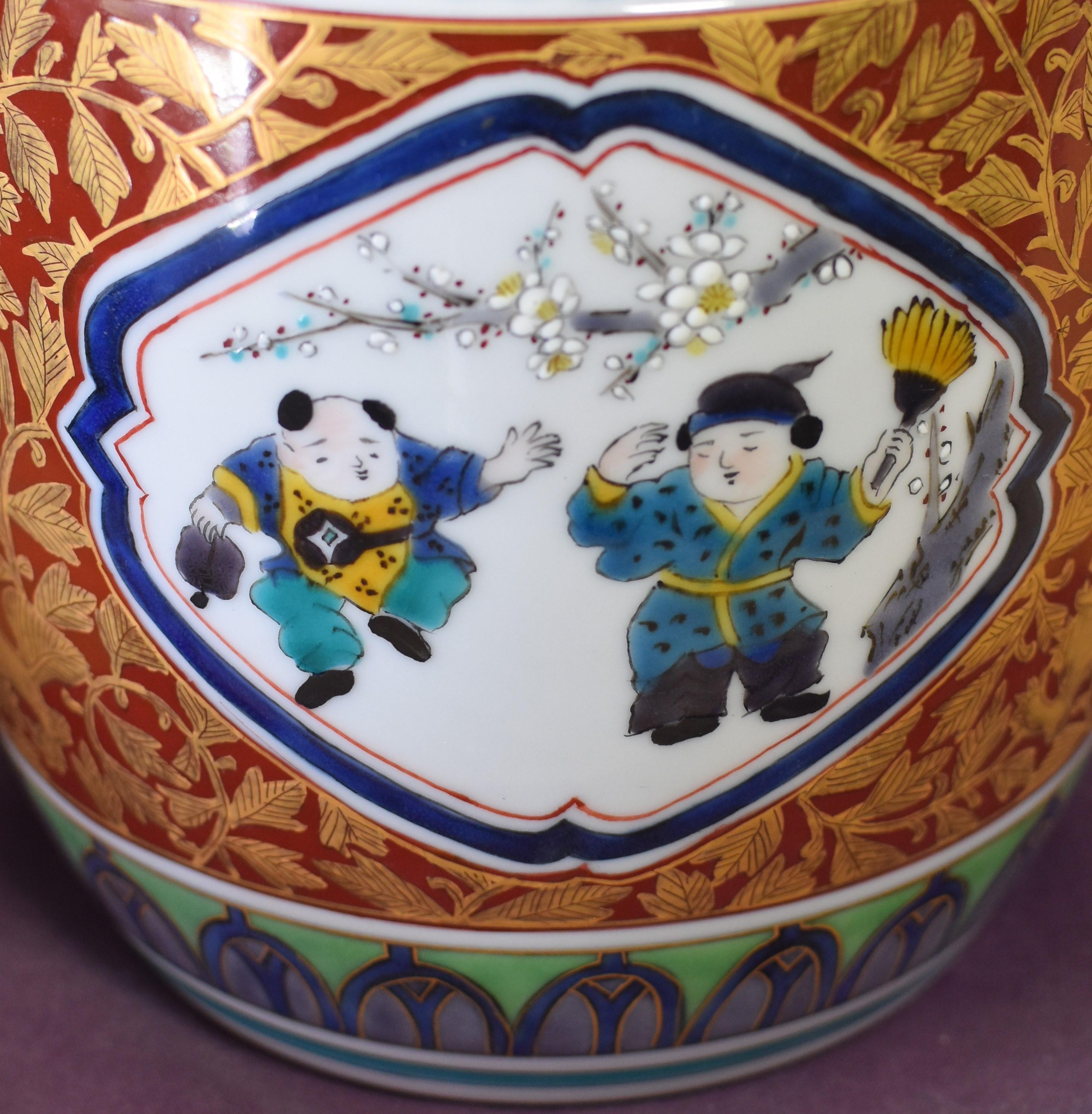 Exquisite Japanese contemporary jar/mizusashi, extremely intricately hand painted in red, green and blue and gilded with pure gold featuring seasonal panels showing children at play and classified as a tomobuta (matching lid) type. This masterpiece