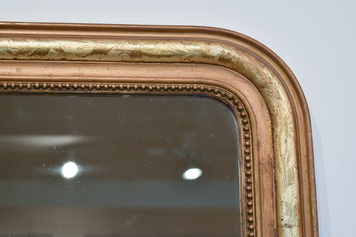 Ce magnifique miroir Louis Philippe illustre l'esthétique raffinée du milieu du XIXe siècle, réputée pour son élégance sobre et son sens pratique. Le cadre du miroir est en bois massif, méticuleusement sculpté de motifs complexes et agrémenté d'une