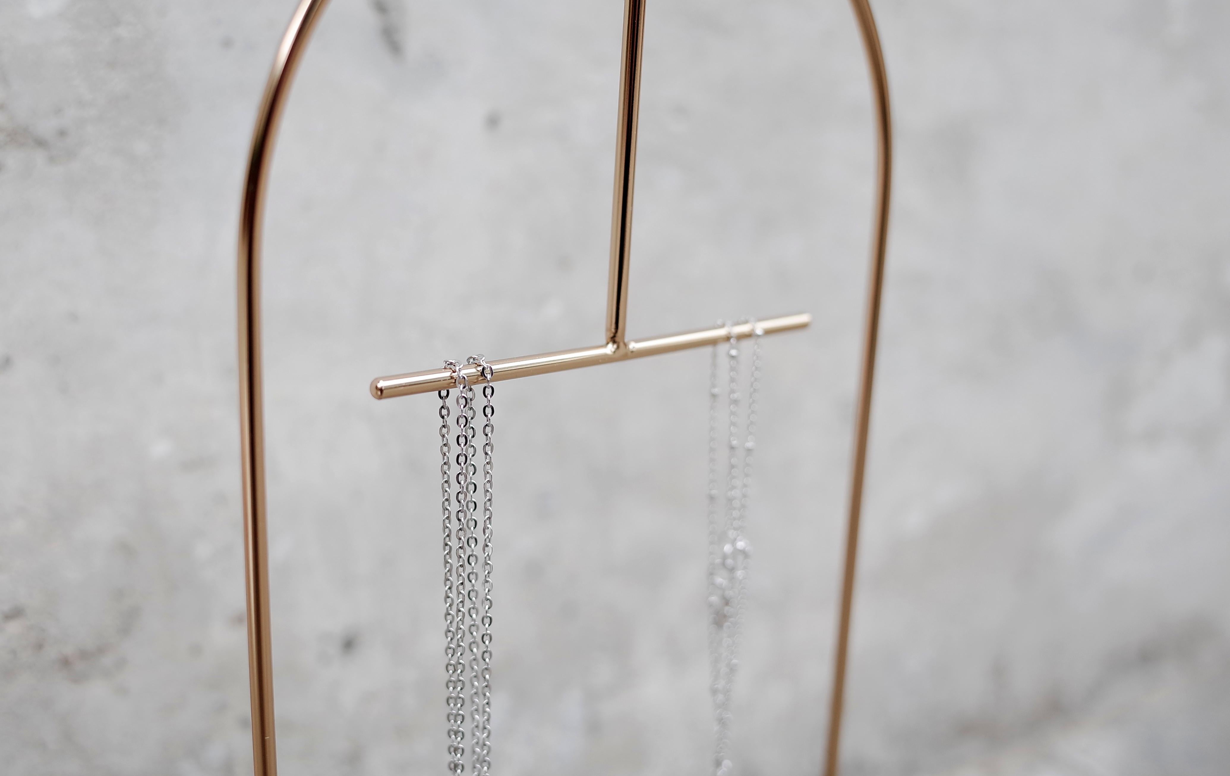 Le support à bijoux Gilded rend l'organisation et la présentation de vos boucles d'oreilles et colliers préférés simples et sophistiqués. Fabriqué en acier inoxydable avec une finition en cuivre et un bassin en marbre, son design minimal met en