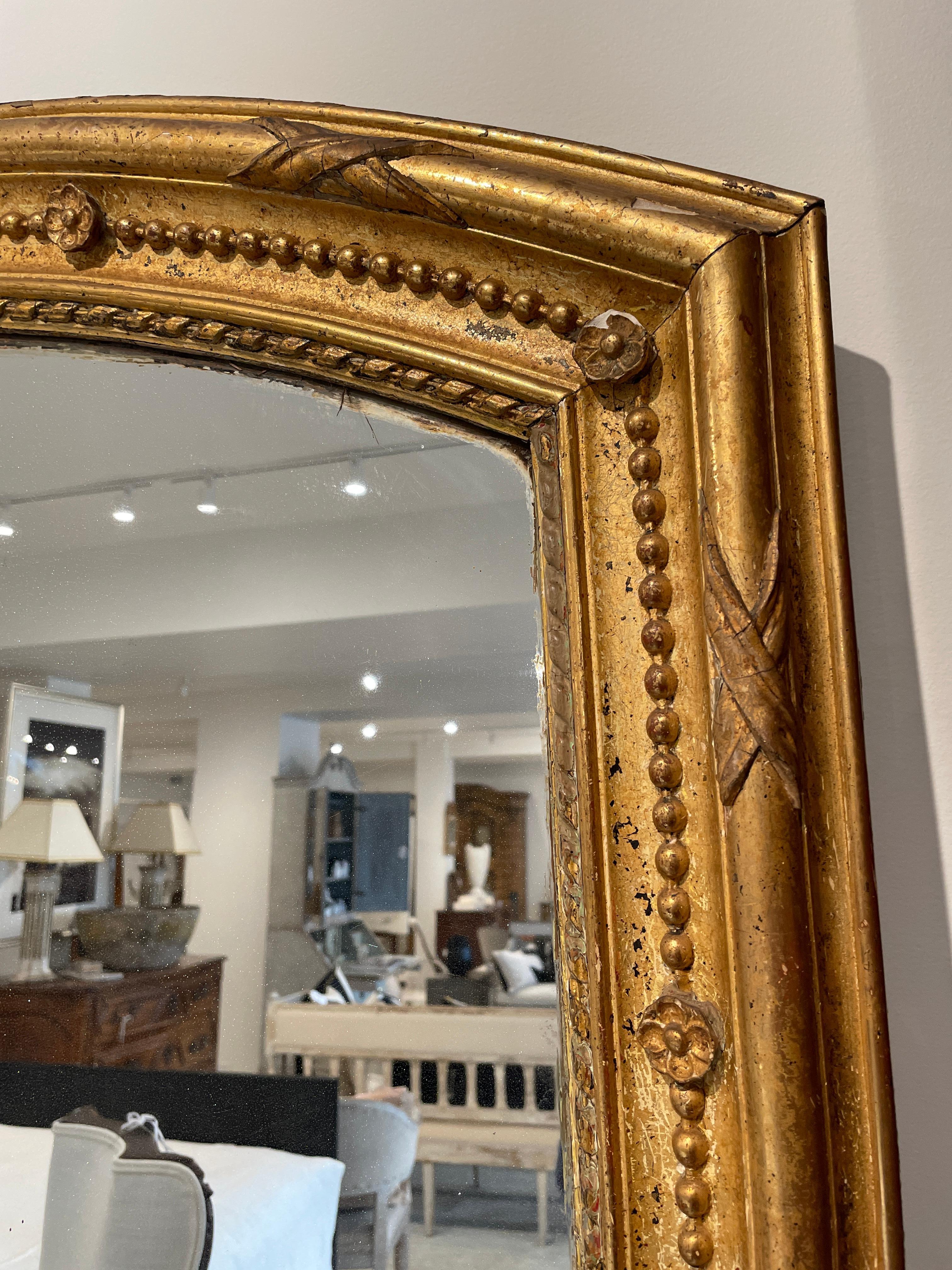 Grand scale and lovely gilding create a hero piece for any space! The arched top gives added interest reinforced by the intricate carving details surrounding the large mirror.
 