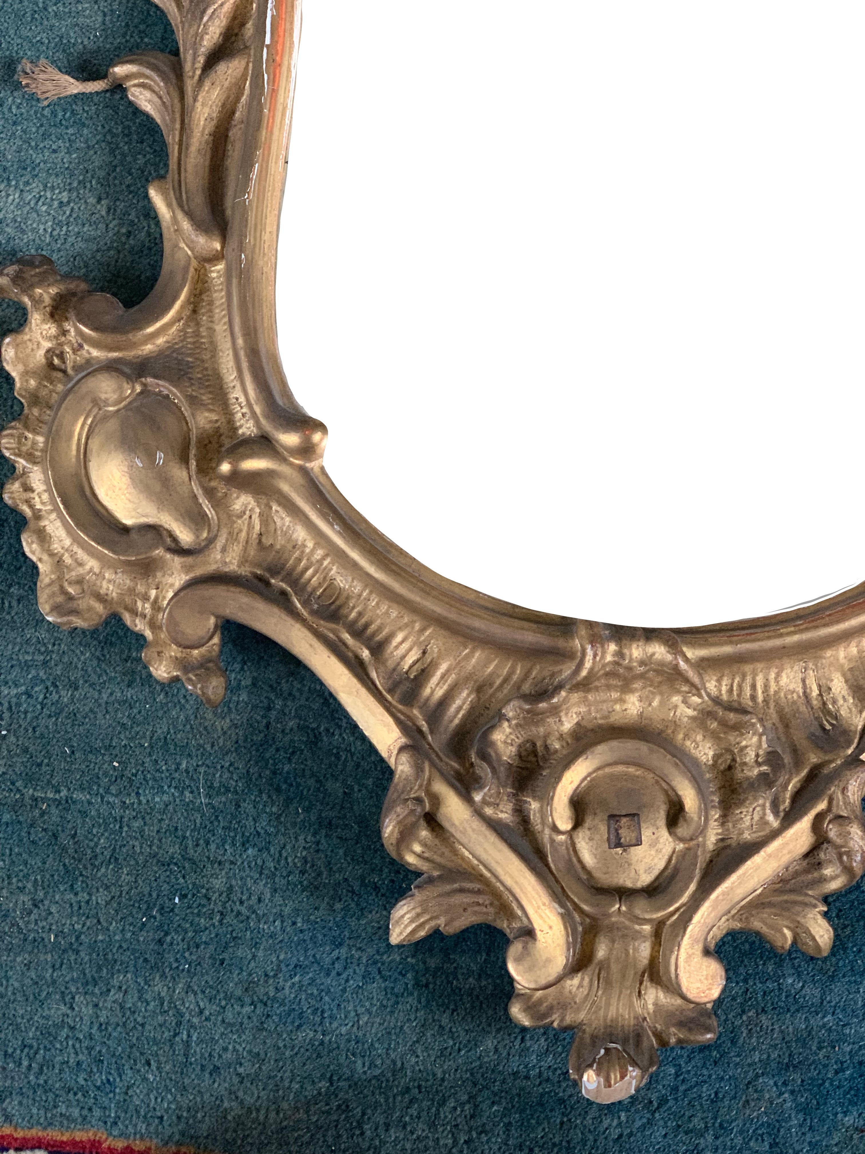 Très beau miroir, de style Regency, un style de transition entre les styles Louis XIV et Louis XV. On reconnaît ce style à ses nombreuses volutes, coquilles et feuilles. Un miroir très délicat et élégant en vogue.
 