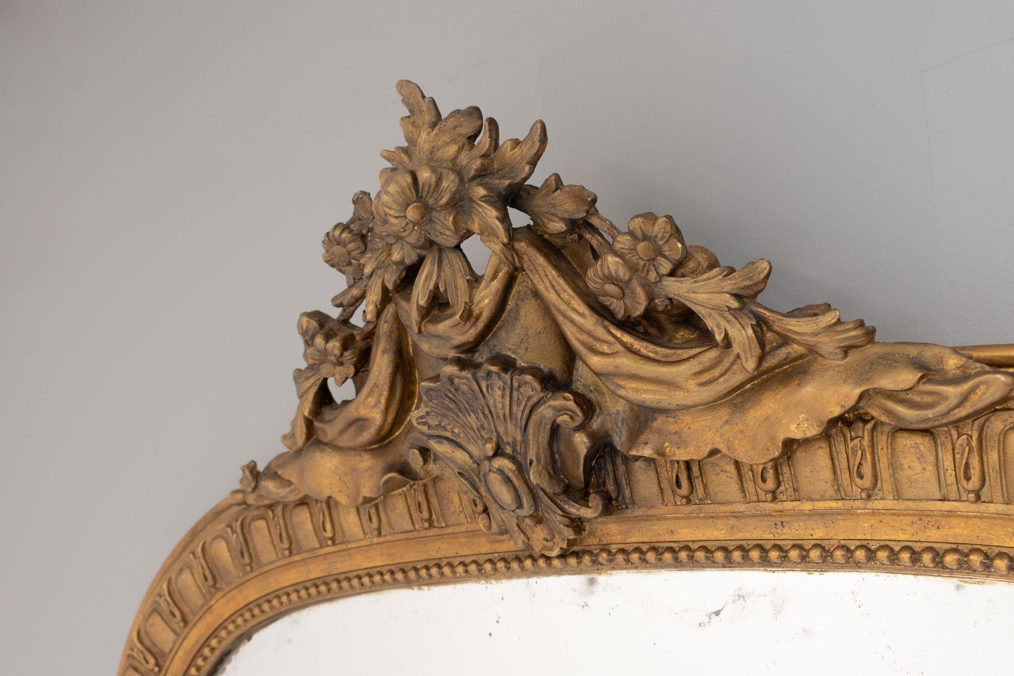 Arch top gilded French overmantel with original plate and crest decoration. Circa 1880.
H 180cm x W 109cm x D 16cm