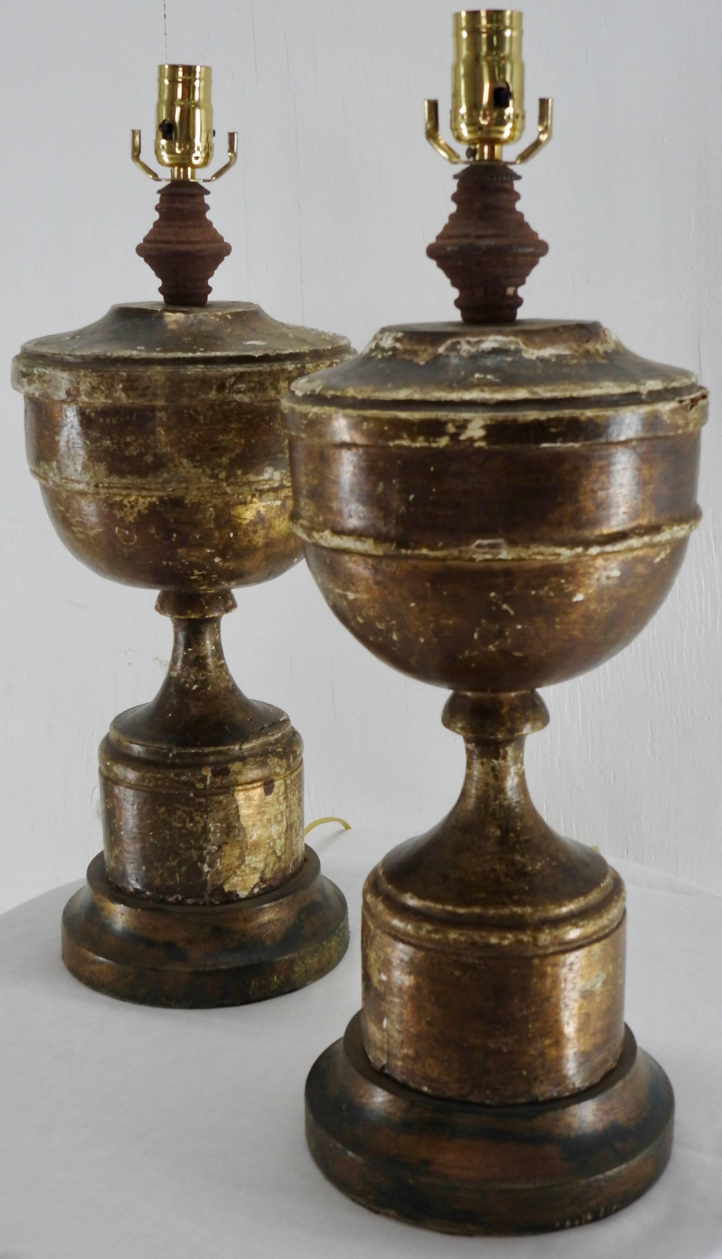 A pair of gilded pedestal electric lamps from the 19th century. The lamps have been restored with new brass push thru sockets and gold cords. Felt has been applied to the bottom. These lamps have a very rustic appearance to enhance your decor.