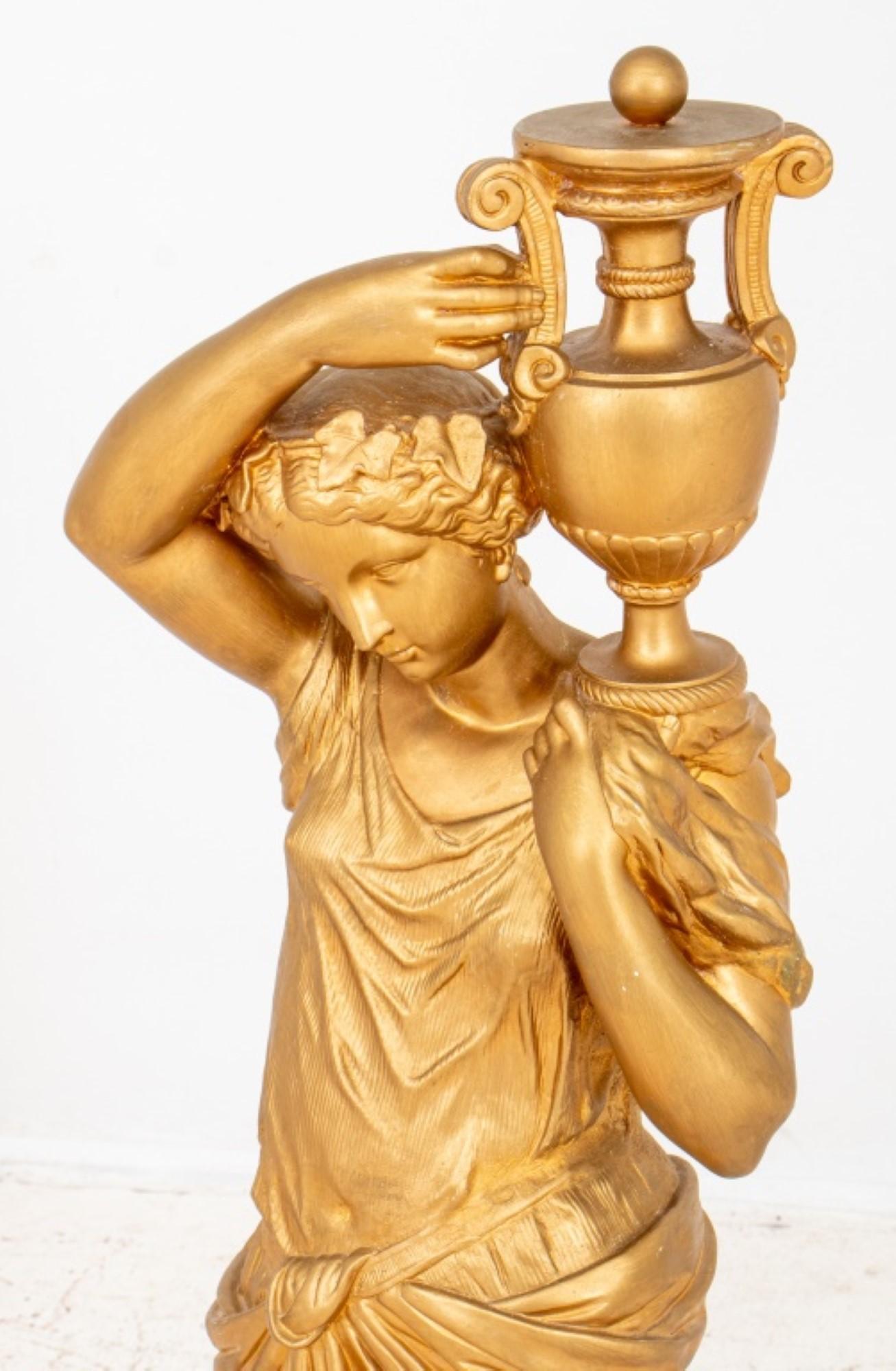 Scultura di figura femminile in gesso dorato in stile neoclassico, forse la dea greca Ebe, che regge un'urna e poggia su una base rotonda.  Diametro. Provenienza: Da una collezione di New York.  
