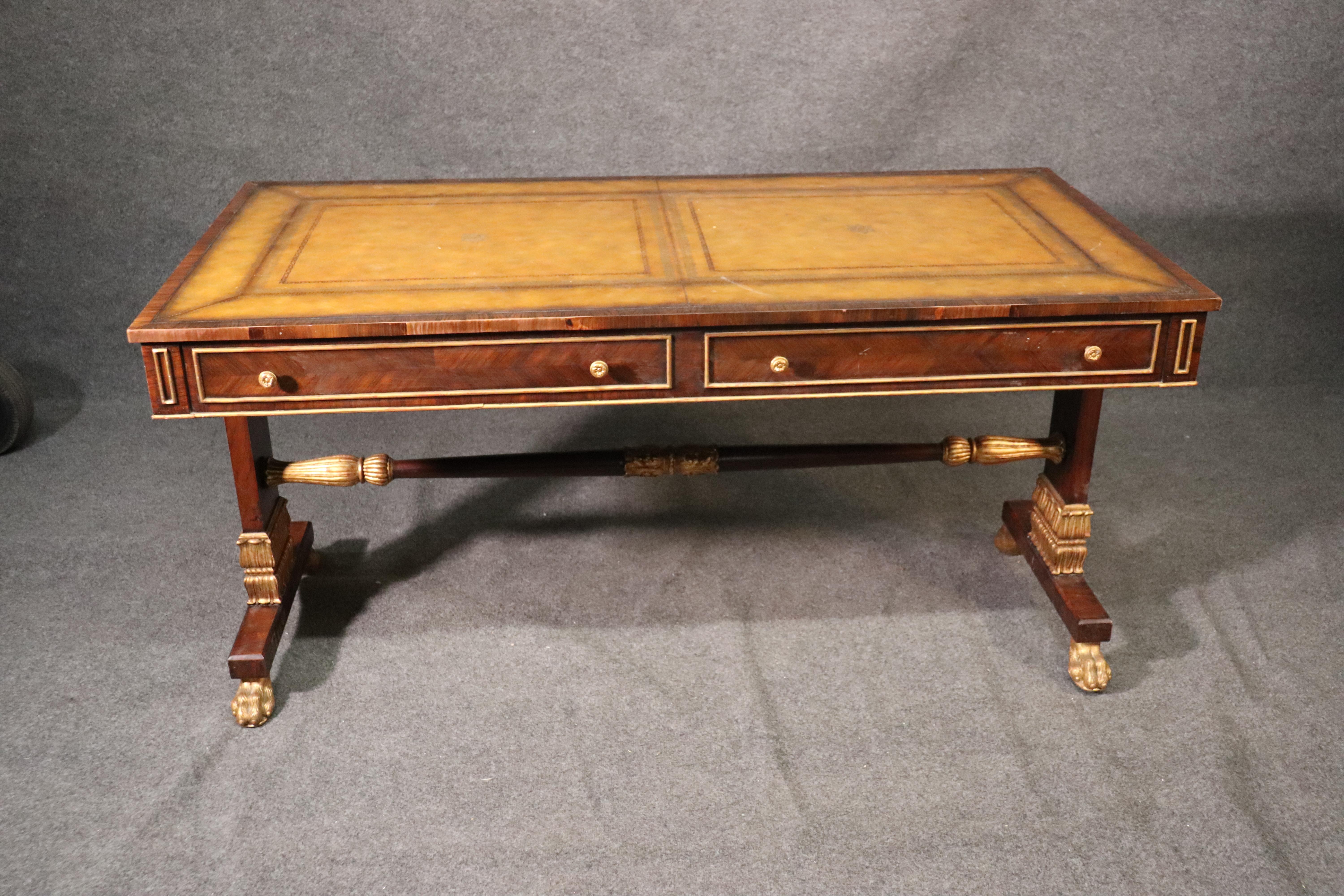 This is a gorgeous yellow ochre leather top desk designed in the manner of the best of English Regency and finished with genuine gold leaf details and a beautiful rosewood case. The desk is in good vintage used condition. The desk measures 60 wide x