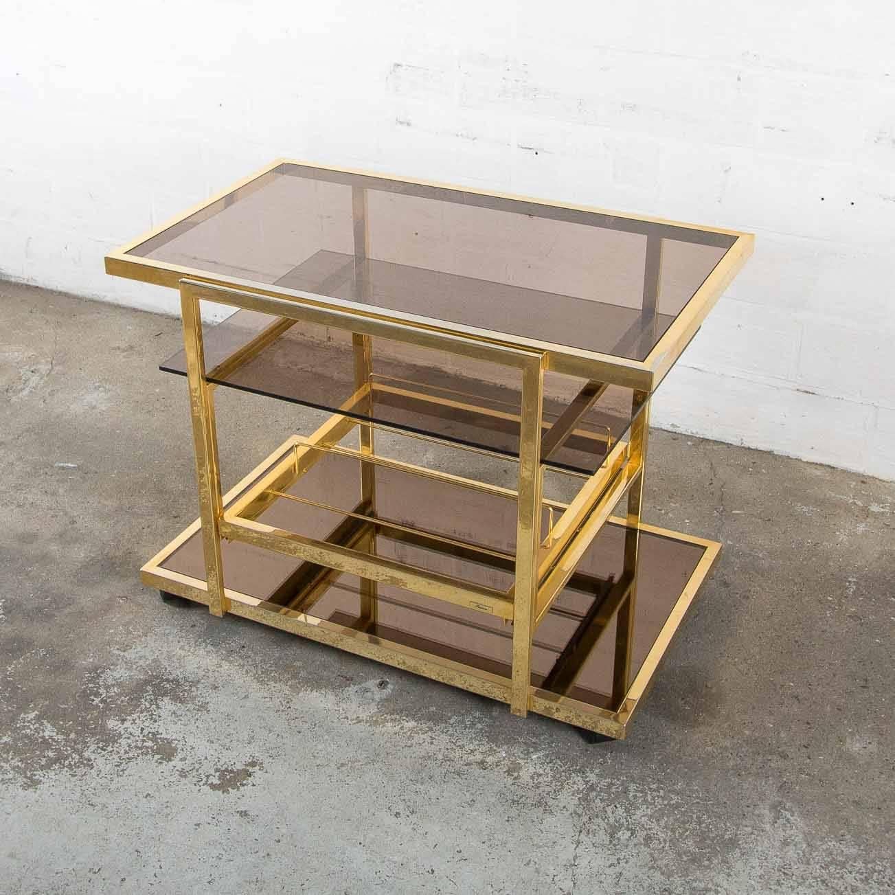 Gilded serving trolley from the brand Fedam.
In good condition, only some minor wear.
With a metal frame in gilded gold and tinted glass.