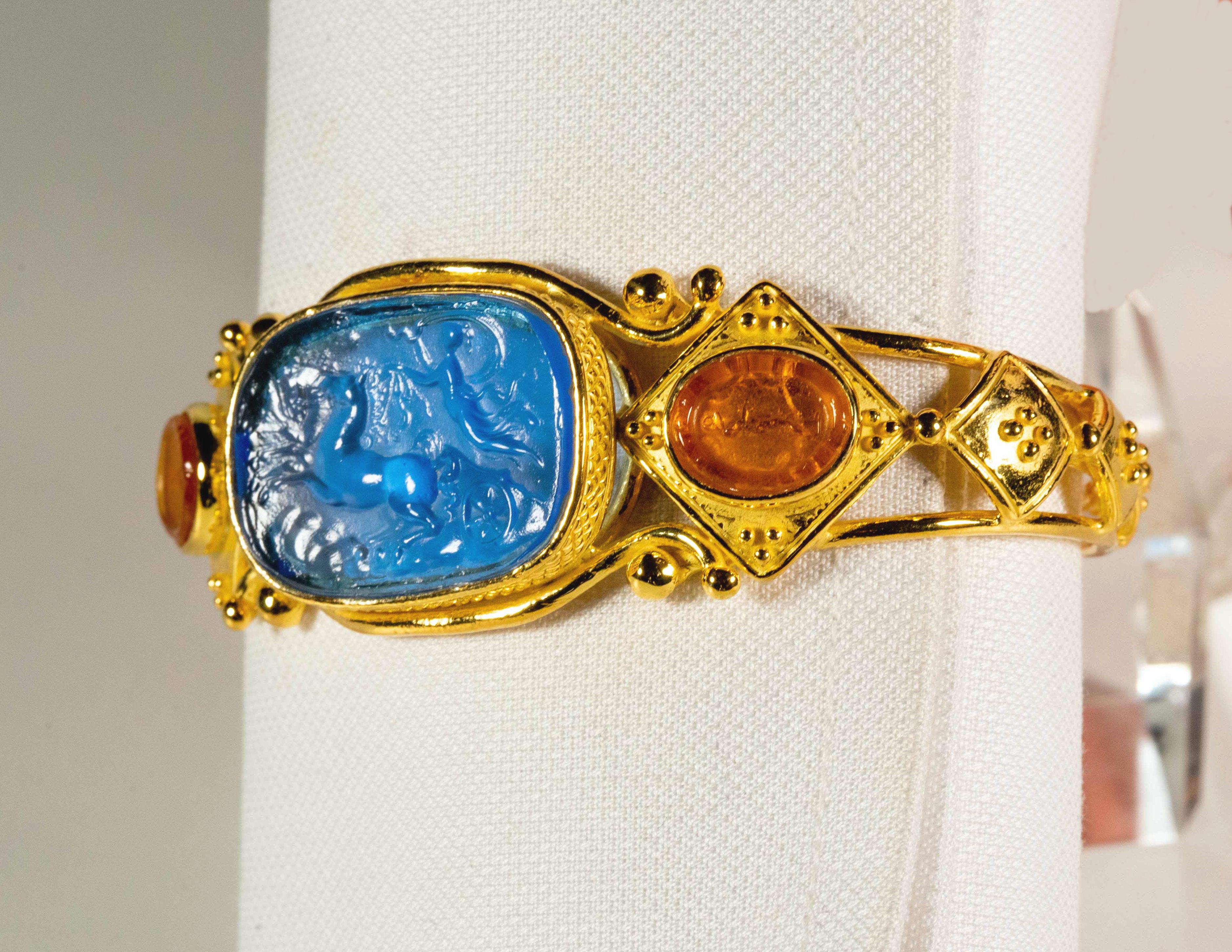 Gracious bracelet in gilded 925 silver with blue and orange cameos made of glass paste, inspired by Etruscan jewels.
The decorative technique with which Etruscans and ancient Romans made the glass paste jewels, on which they depicted scenes of