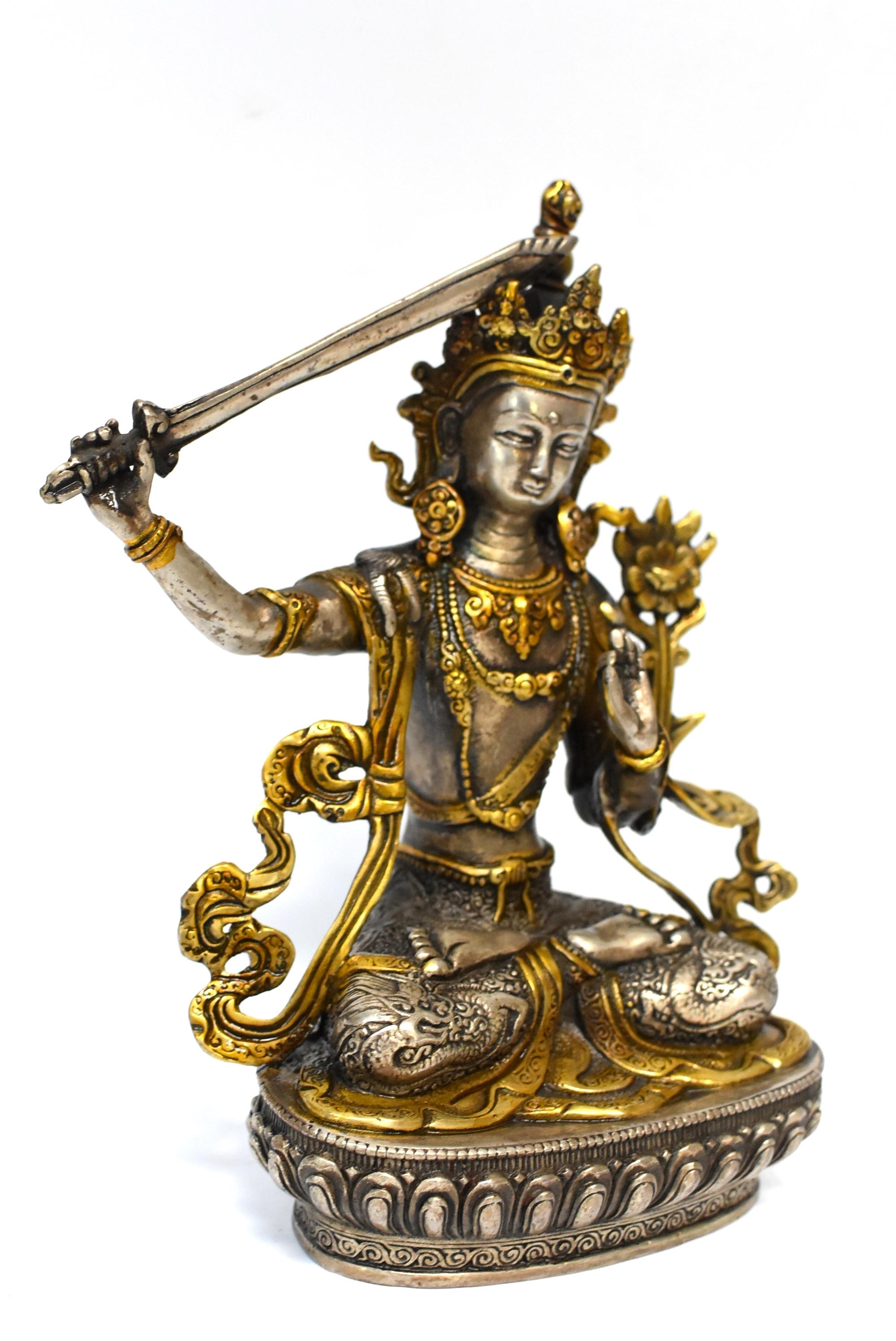 A beautiful statue of silvered bronze Tibetan Bodhisattva Manjushree with accent of golden highlights. Legend has it that he cuts water with the sword to divide the water resource to irrigate dry valleys. Manjushree is the God of Wisdom. In this
