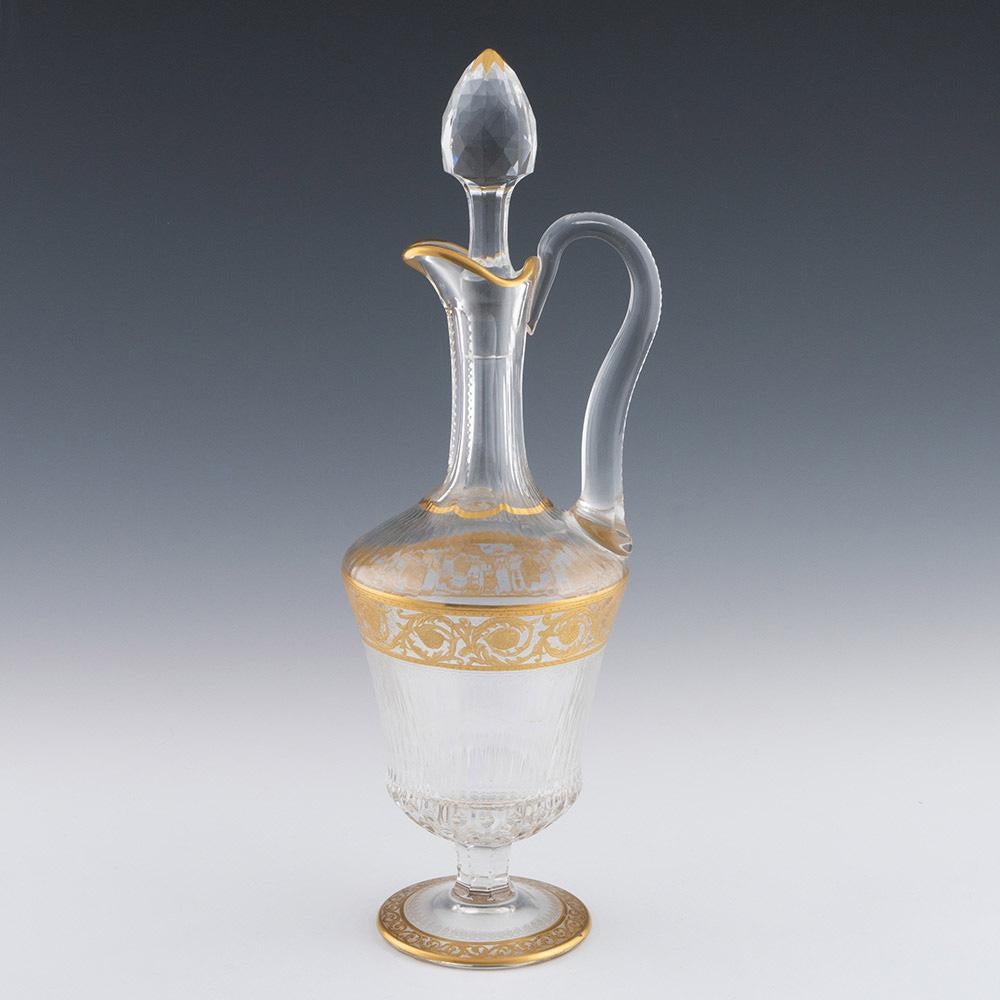 Heading : Gilded St Louis claret jug in the Callot pattern c1930
Date : c1930
Origin : St-Louis-lès-Bitche, France
Colour :  Clear with gilding
Stopper : Faceted with gilded tip
Neck : Slice cut with notch cutting
Body: Gilded baroque-style band ,