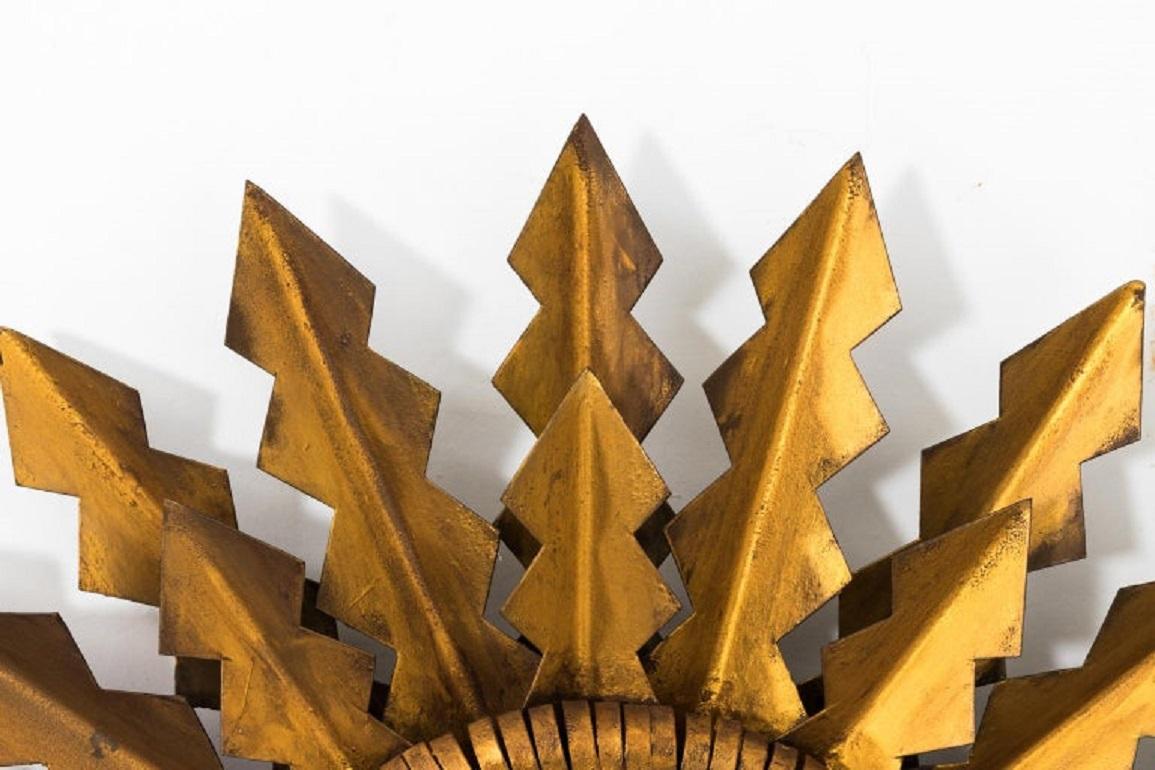 Brilliante toleware sunburst round mirror, made in Spain in the early 20th century. Des flèches dorées rayonnent du miroir circulaire en deux rangées, ajoutant de la dimension et de la texture. Le verre du miroir d'origine présente une certaine
