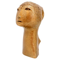Scultura di testa di donna in terracotta dorata