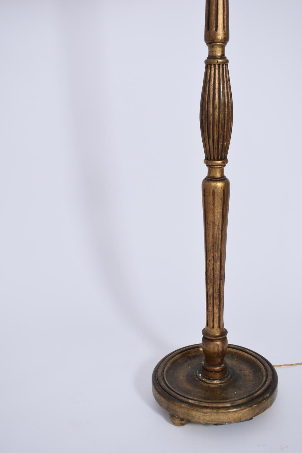 Lámpara de pie de madera torneada dorada con base redonda. Francia, años 30 