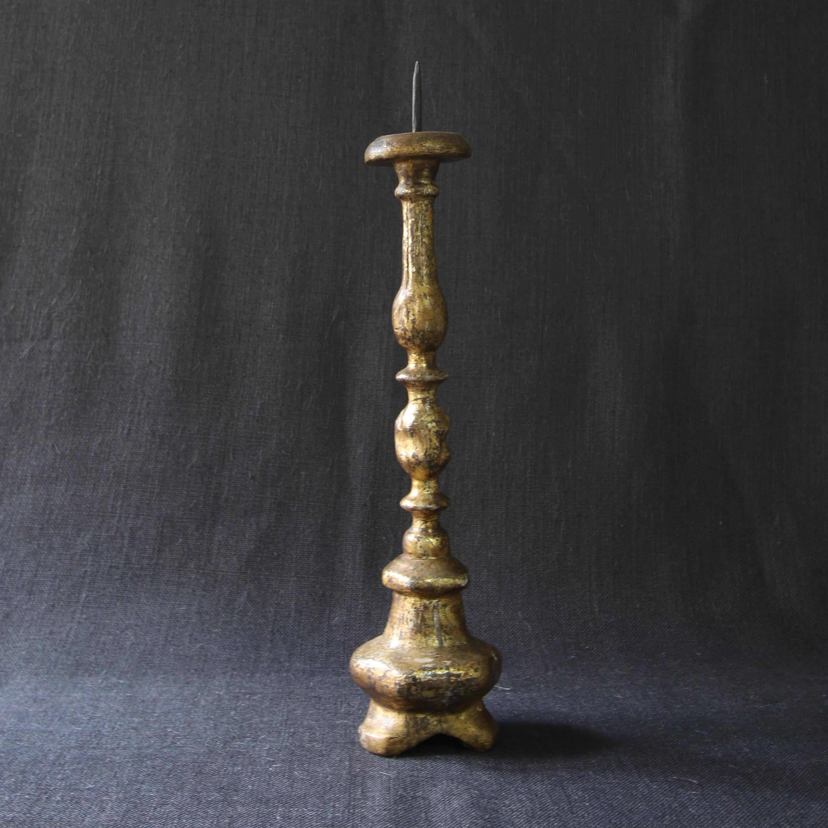 This gilded wood candle spike dates back to the 18th century. It's original patina gives to it a special charm. The irregularities of its shape testify to its antiquity.