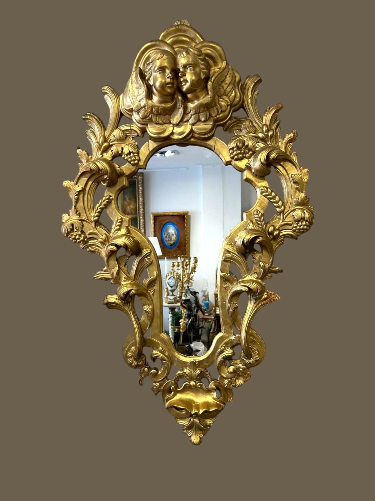 Espejo de Madera Dorada con Putti, Italia, Siglo XIX 

Espejo de tamaño putti muy decorativo y bello, del siglo XIX, realizado en estilo rococó italiano con un bello dorado en pan de oro.

Tiene forma de trilóbulo en su parte superior y está