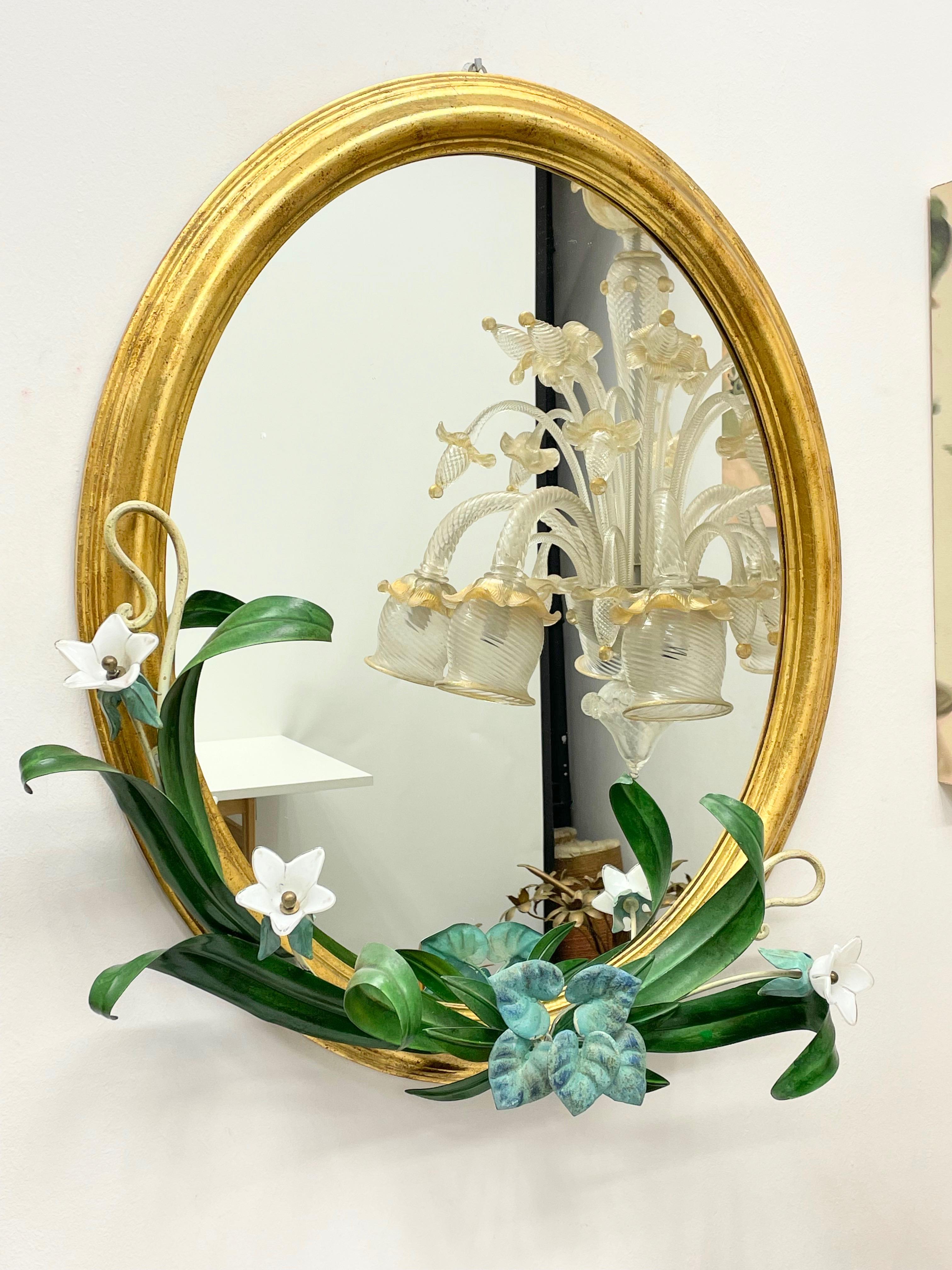 Beautiful gilded wood frame wall mirror in Hollywood Regency style, vintage Italy, 1960s. Surrounded by cold painted metal leafs with glass Flowers. Nice addition to any room or hall entry.