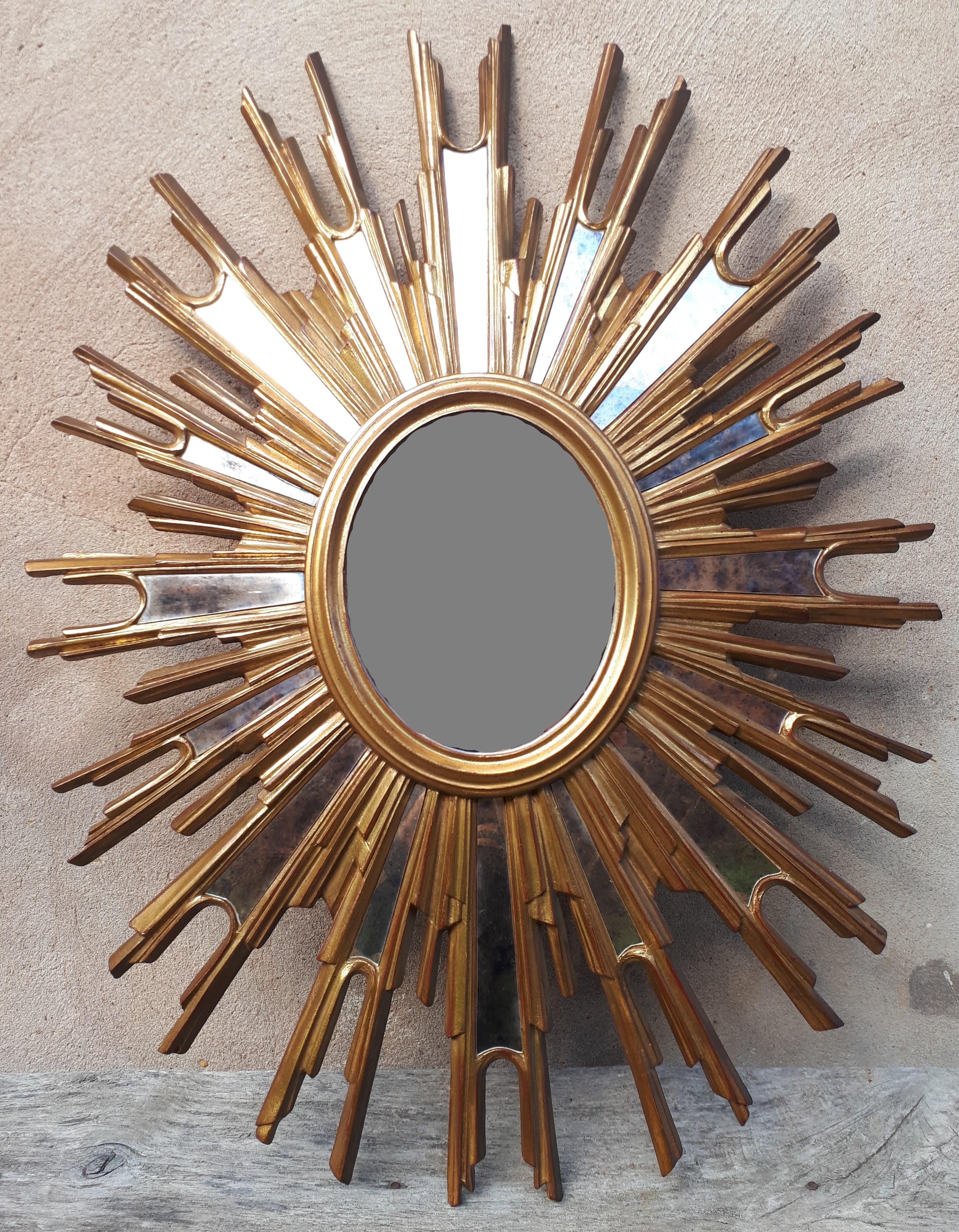 A carved and gilded wooden witch's mirror with a central glazing and sixteen beads radiating around it.
Bears the number ‘973’ on the back.
France, 1950s.