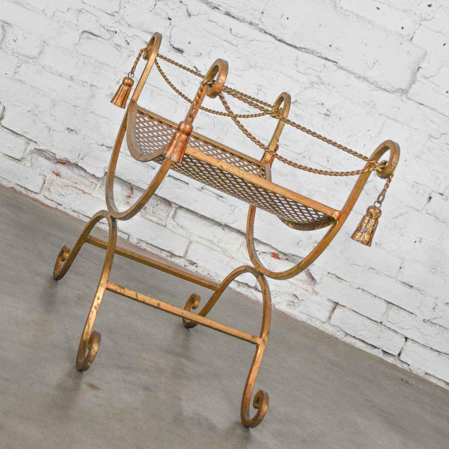 Wonderful, gilded wrought iron Italian Hollywood Regency vanity stool with twisted rope and tassels detail in a Curule or Savonarola style. This piece is in wonderful vintage condition. However, it does have a few signs of wear where the gilding is