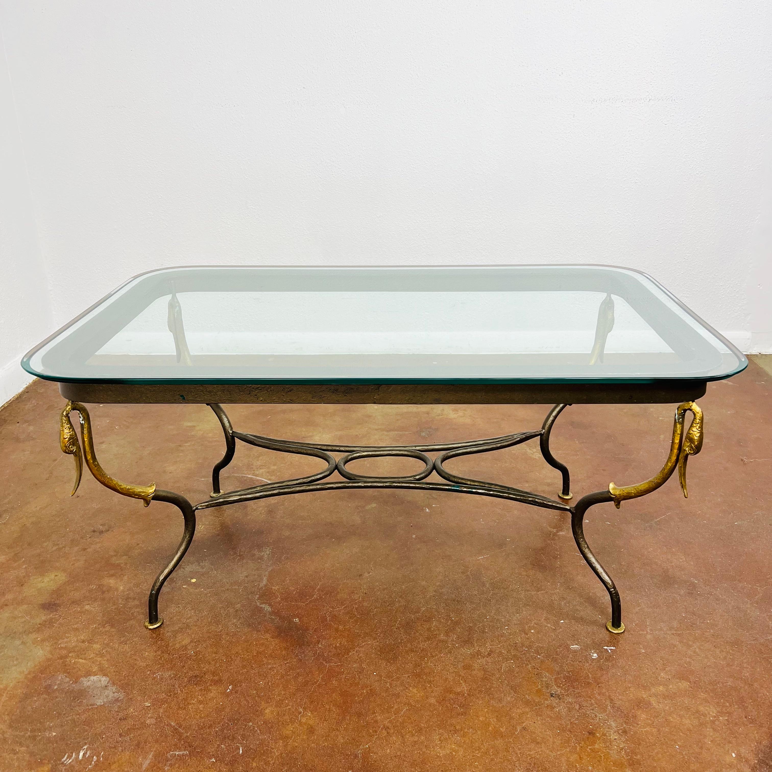 This rare 1920's French Empire swan coffee table is made of wrought iron with gilded accents. Very heavy and sturdy with beveled edge glass top. Good vintage condition with normal cosmetic wear due to age and use.