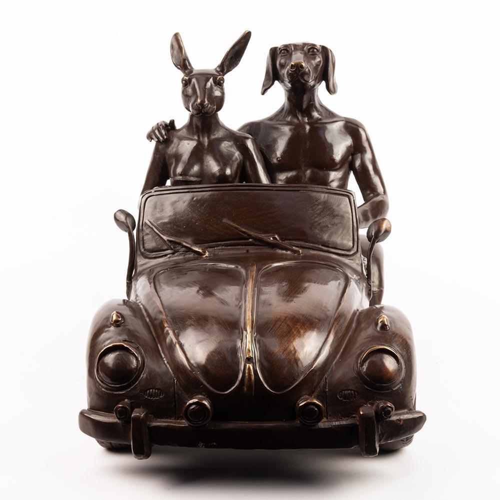 Title: They had the VW Car Bug
Authentic bronze sculpture

This authentic bronze sculpture titled 'They had the VW Car Bug' by artists Gillie and Marc has been meticulously crafted in bronze. It features a Dogman and Rabbitwoman sitting in the VW