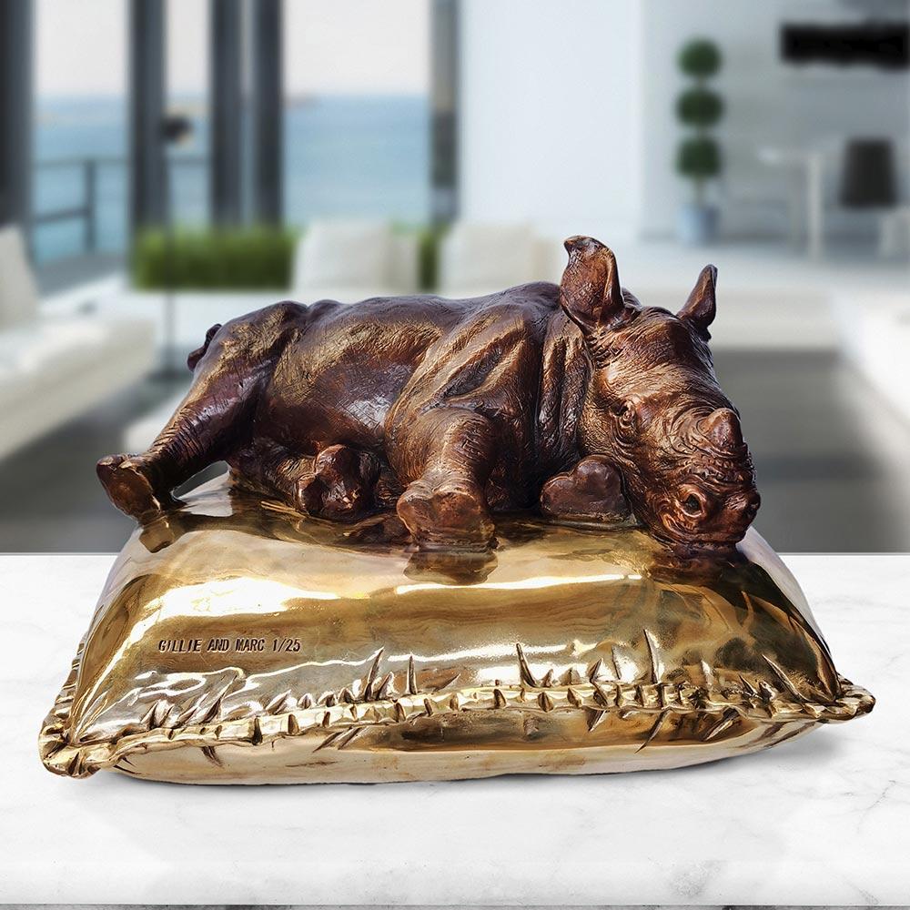 Title: Sleeping Beauty Rhino 
Authentic Bronze Sculpture

This authentic bronze sculpture titled 'Sleeping Beauty Rhino' by artists Gillie and Marc has been meticulously crafted in bronze. It features a Rhino having a fabulous nap on a comfy gold