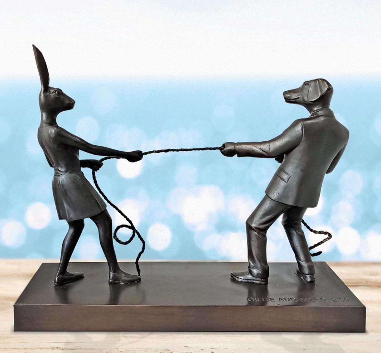 Titled: Tug Of Love 
Authentic Bronze Sculpture

Description:
This authentic bronze sculpture titled 'Tug Of Love' by artists Gillie and Marc has been meticulously crafted in bronze. It features a Gillie and Marcs famous dogman and rabbitwoman