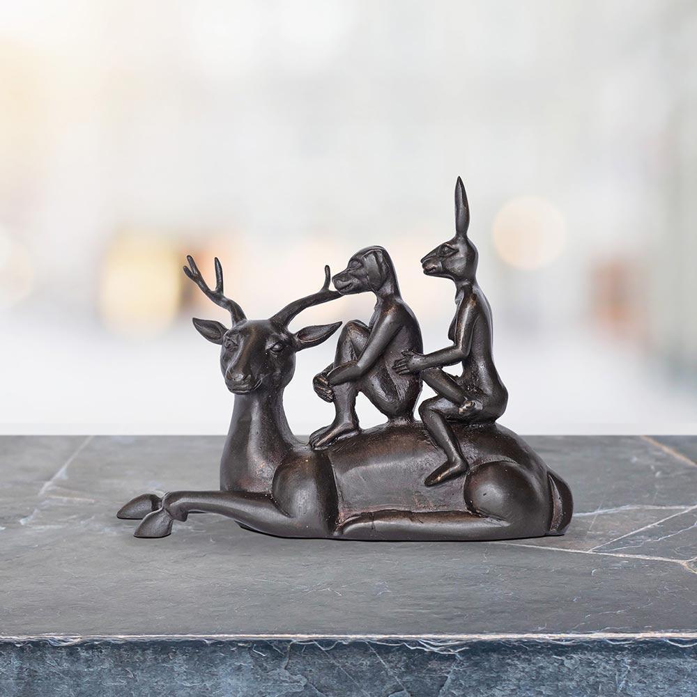 Title: The deer riders
Authentic bronze sculpture

This authentic bronze sculpture titled 'The Deer Riders' by artists Gillie and Marc has been meticulously crafted in bronze. It features a Gillie and Marcs famous Dogman and Rabbitwoman riding a