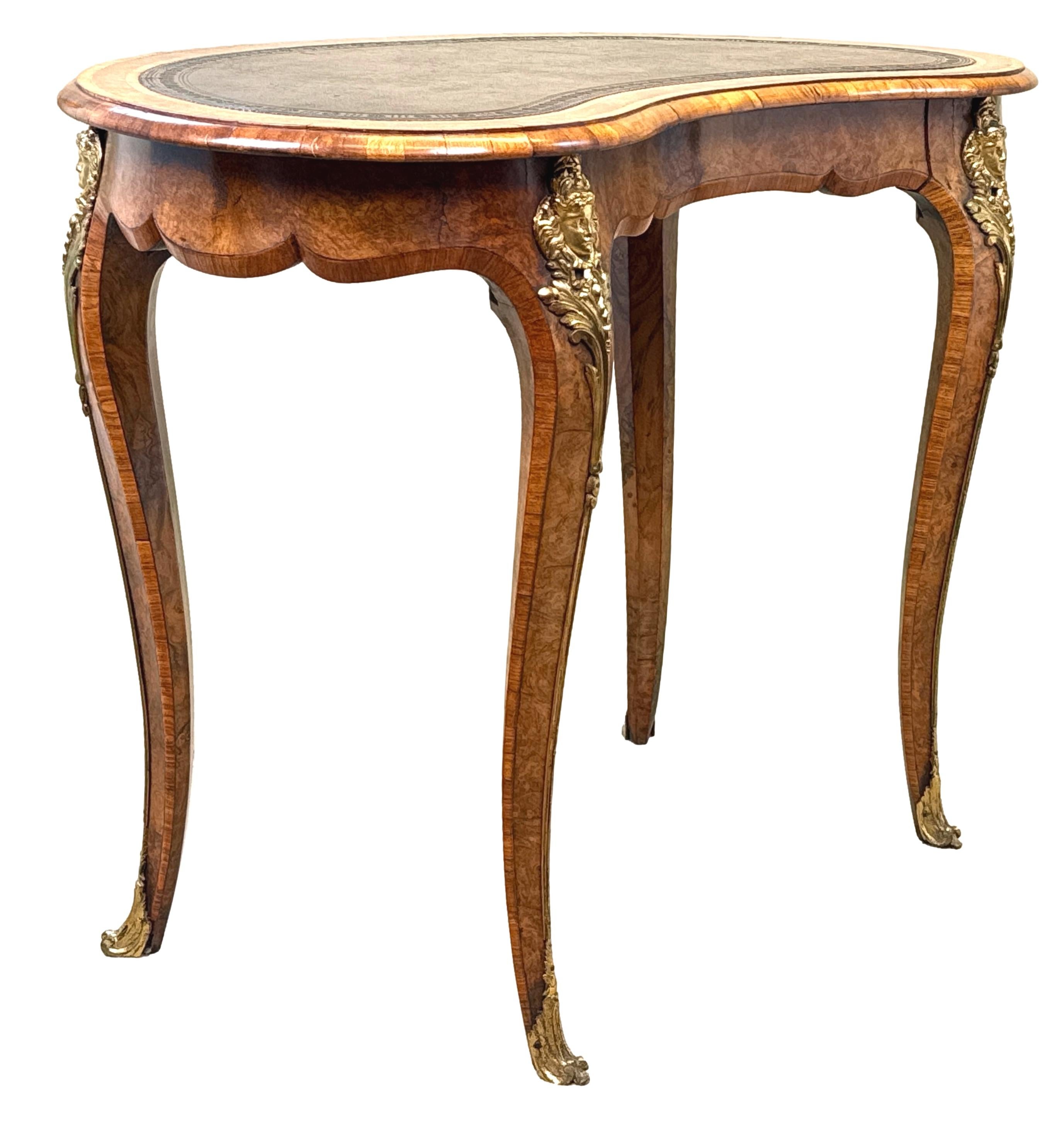 Table à écrire en forme de rein, en ronce de noyer, de qualité exceptionnelle, datant du 19e siècle et de l'époque victorienne. Elle est ornée d'un cuir ancien attrayant et d'un décor estampé à l'aveugle, inséré dans un plateau à bandes croisées,