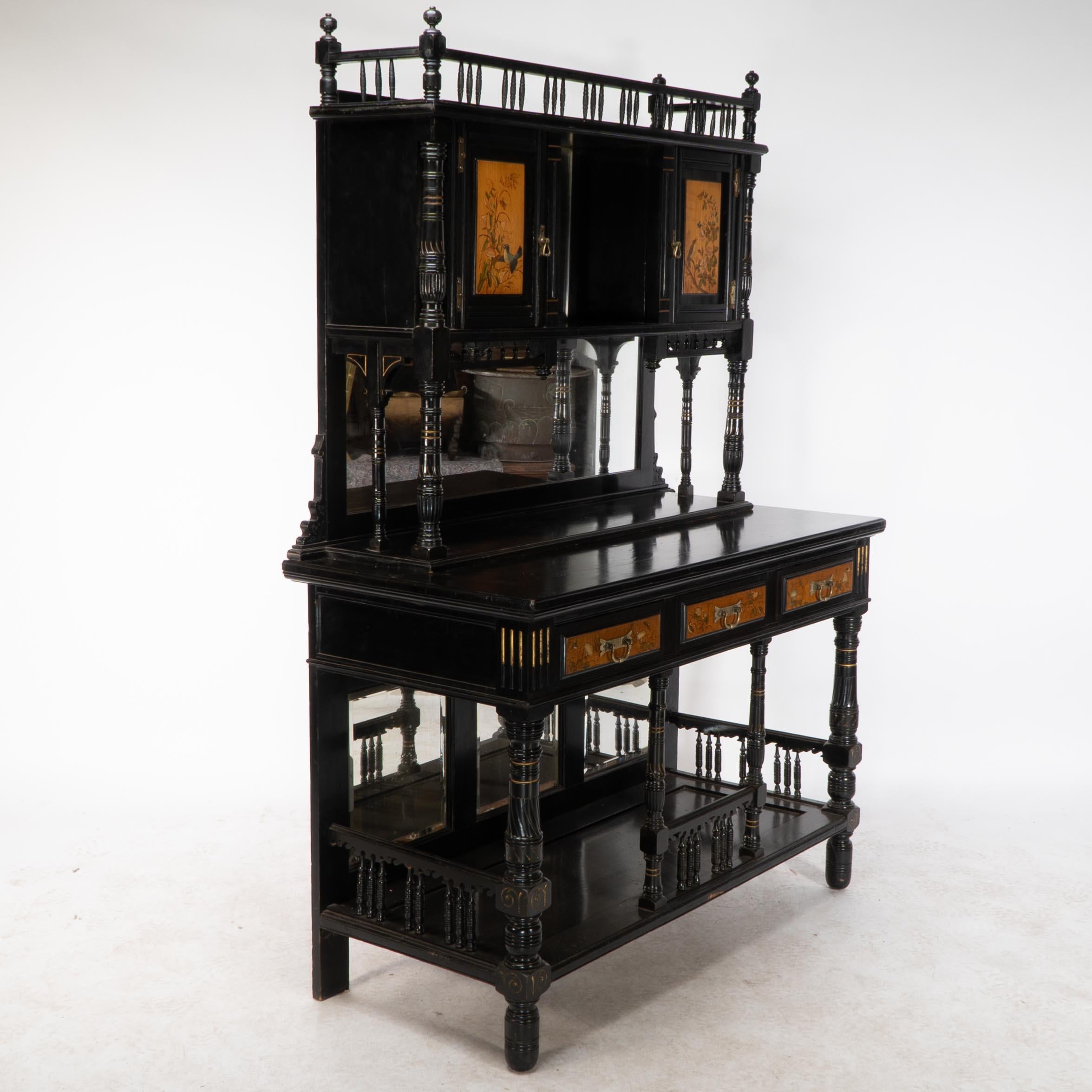Ebonized Gillows. A fine Aesthetic Movement side cabinet with hand painted floral panels For Sale