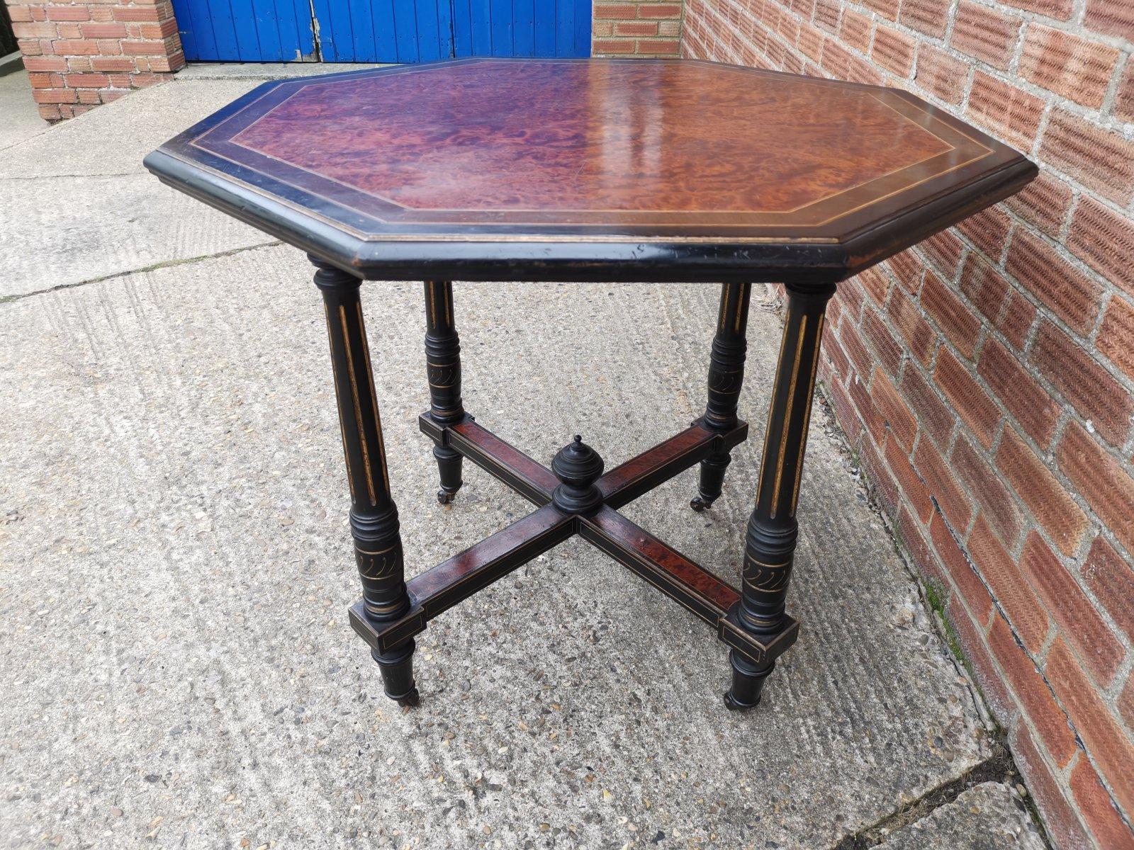 Gillows attributed.
An Aesthetic Movement Ebonized Mahogany Octagonal Centre Table with a wonderful burr Amboyna top with line inlay and ebonized to the edges.
The four turned legs with incised gilt decoration united by a cross stretcher with