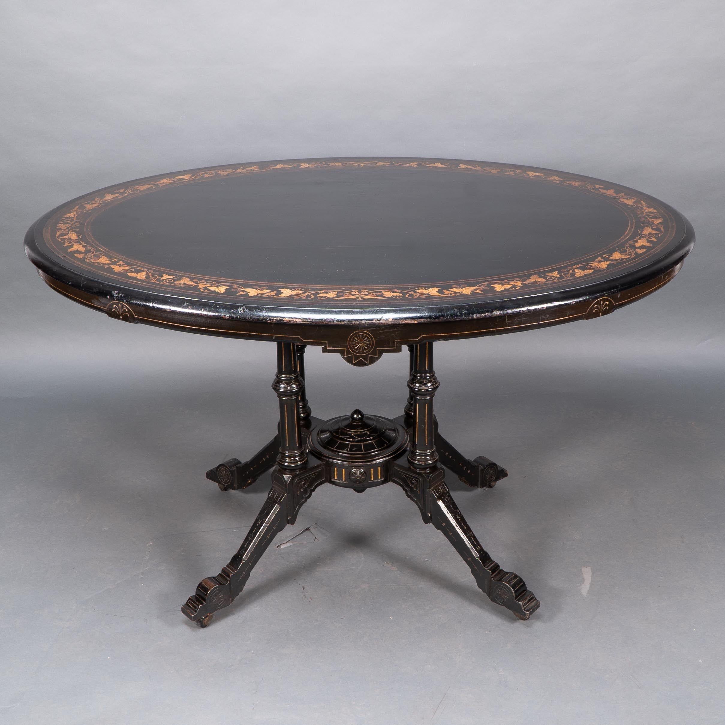 Gillows of Lancaster attributed. An Aesthetic Movement tilt top dining table with floral inlays to the oval top walnut.
Stamped mark under the top 8198