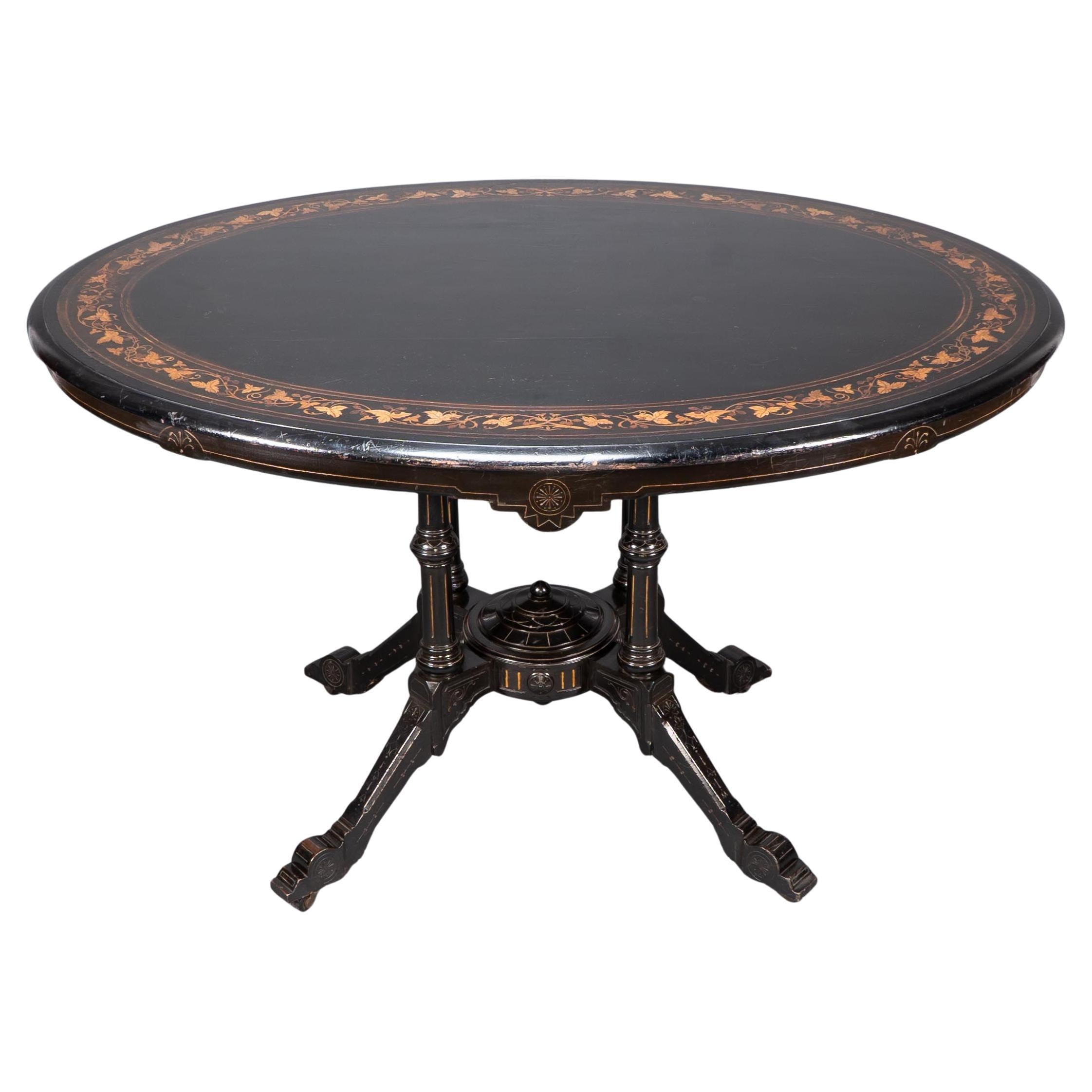 Gillows attr. An Aesthetic Movement tilt top dining table with floral inlays