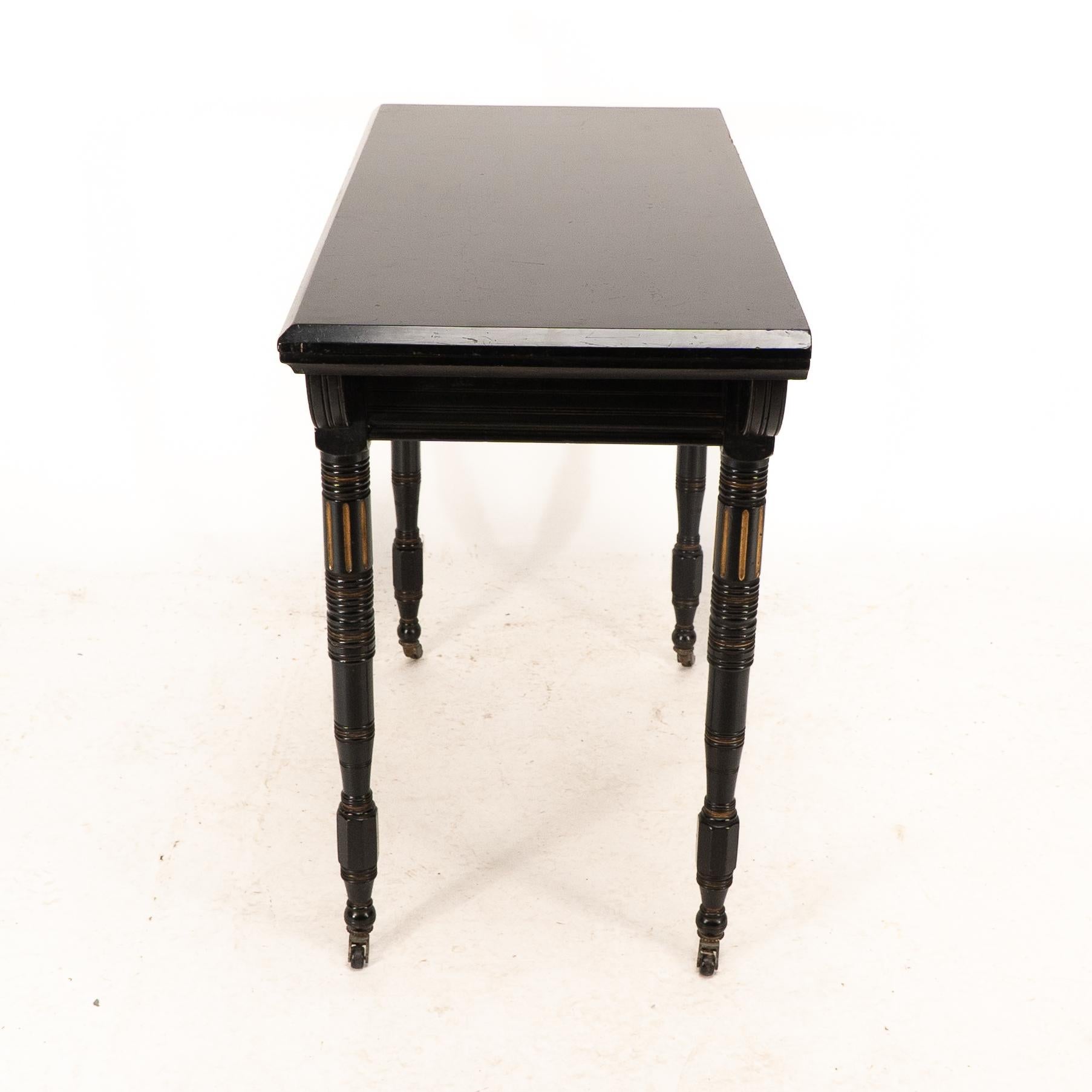Walnut Gillows attributed. An Aesthetic Movement ebonized games and card table