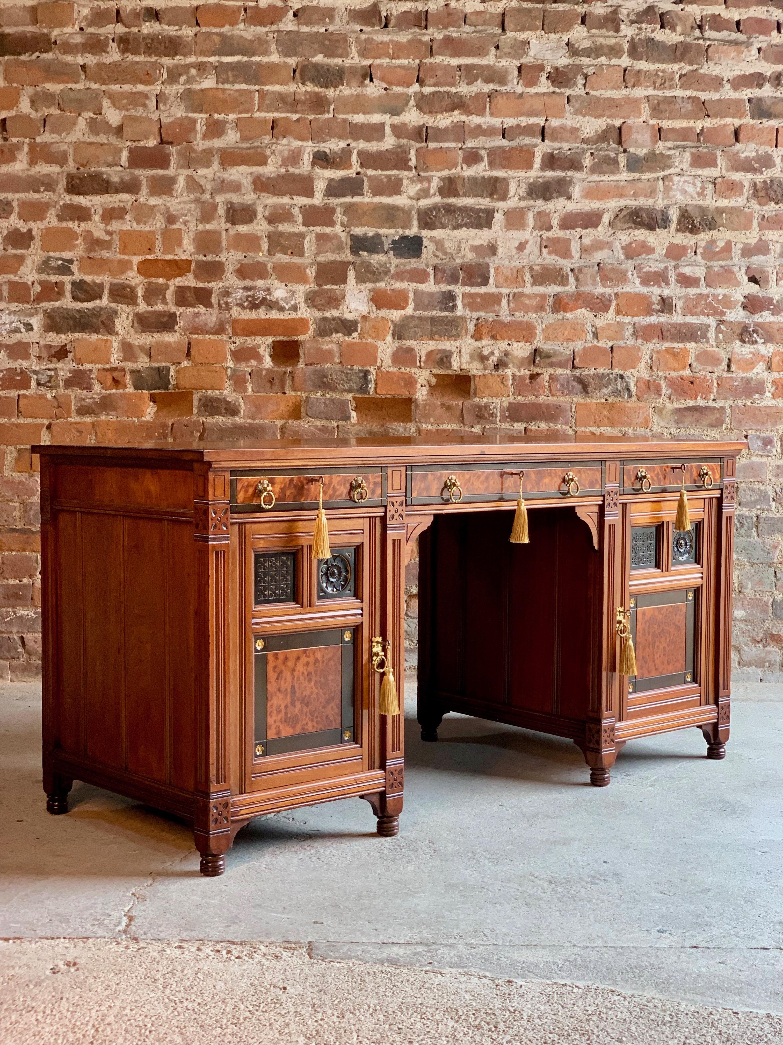 An aesthetic period Gillows of Lancaster walnut twin pedestal desk, circa 1870, the Geometric Gothic style after a design by Bruce Talbert, inlaid with Thuya and Ebony, stamped inside drawer 'Gillow L3910’, the rectangular top over a central frieze