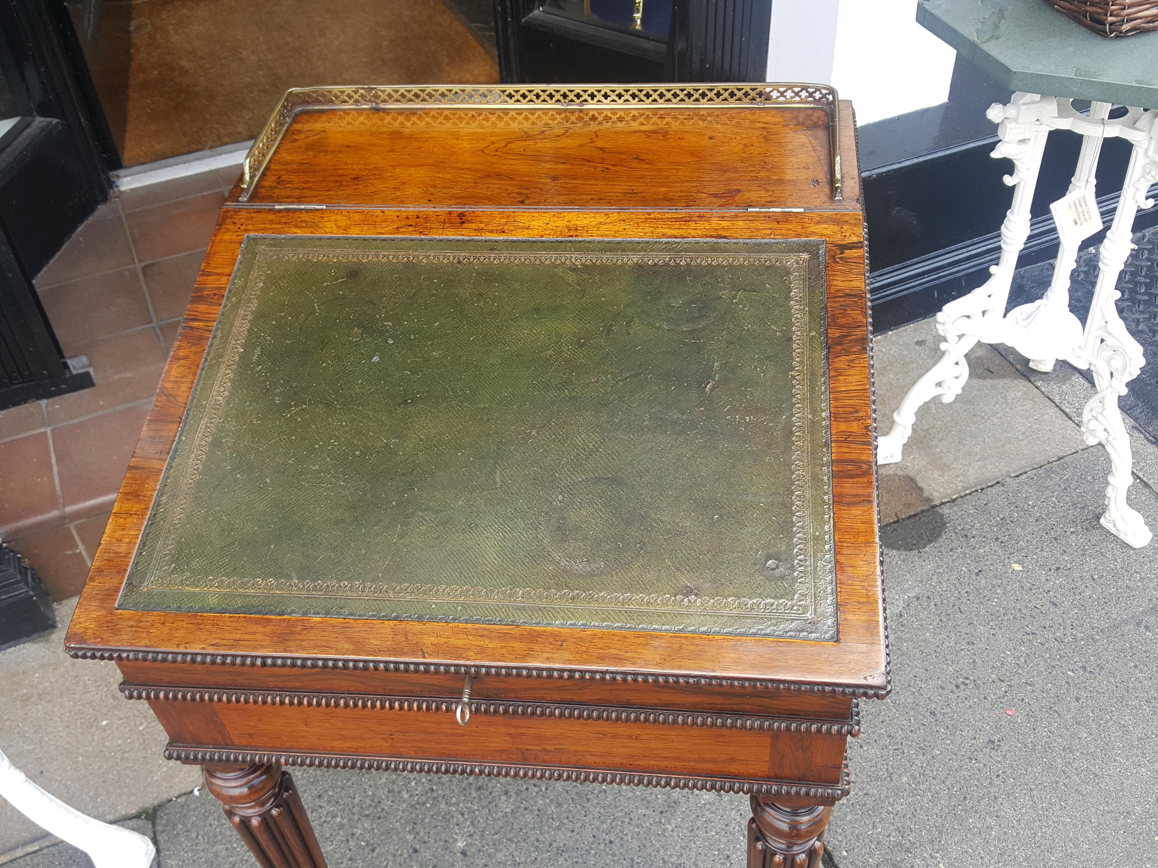 Early Victorian rosewood Davenport desk, the slope with a leather inset surface, brass gallery edge to top, the lid opening to reveal a fitted interior, “secret” trays and pen drawer and movable top, raised on turned and reeded legs – Gillows of