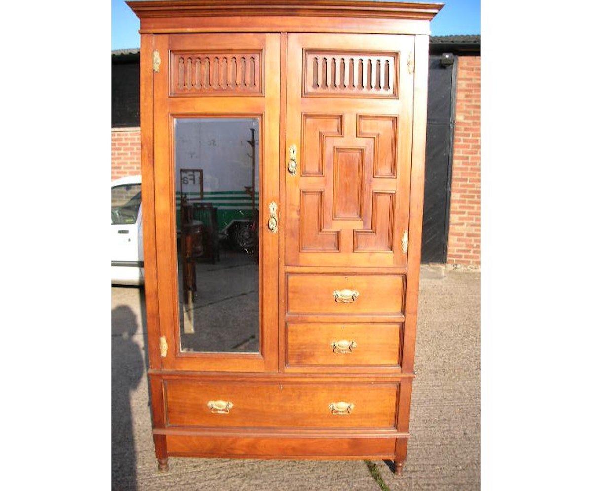 Gillow's of Lancaster, an Aesthetic Movement walnut armoire wardrobe compactum with lots of useful storage space.
The moulded cornice and blind fretwork details to the upper doors with double hanging space behind, the left hand side with the