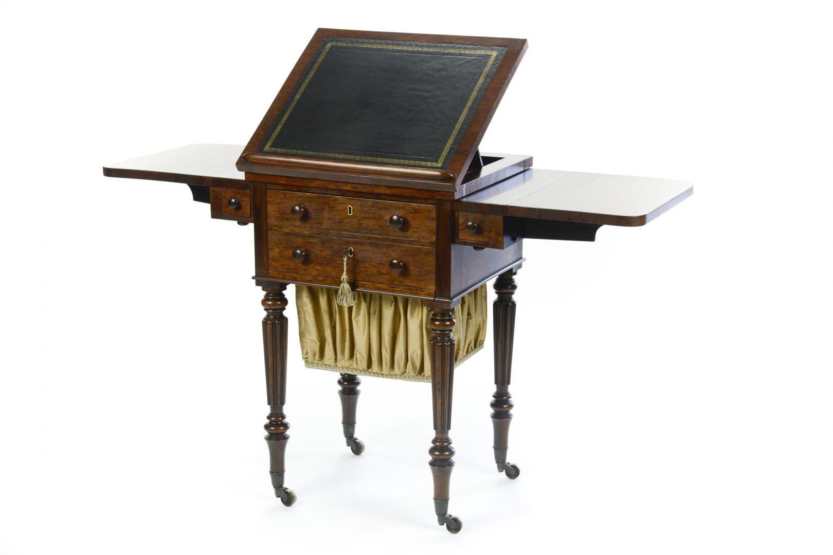 Gillows, early 19th century rosewood drop leaf work table, with a writing slope that slides forward to facilitate its use as a desk, also fitted with two pen draws, also with two draws and a removable sewing basket. Stamped Lodge and Co. Lodge and