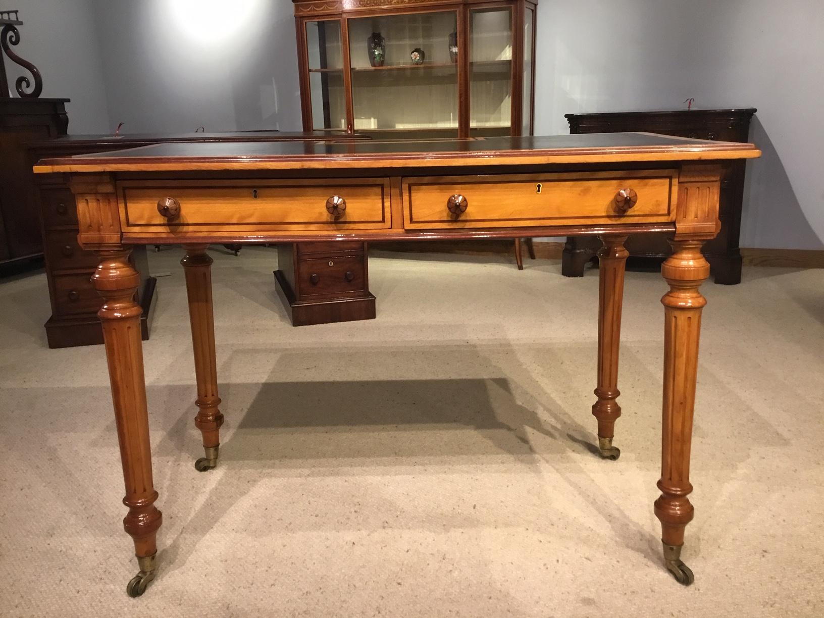 A fine quality satinwood and purple heart Victorian Period writing table by Gillows Of Lancaster. Having a satinwood rectangular top with a fine quality black leather writing surface and an unusual pop up compartment for ink wells and pens (a