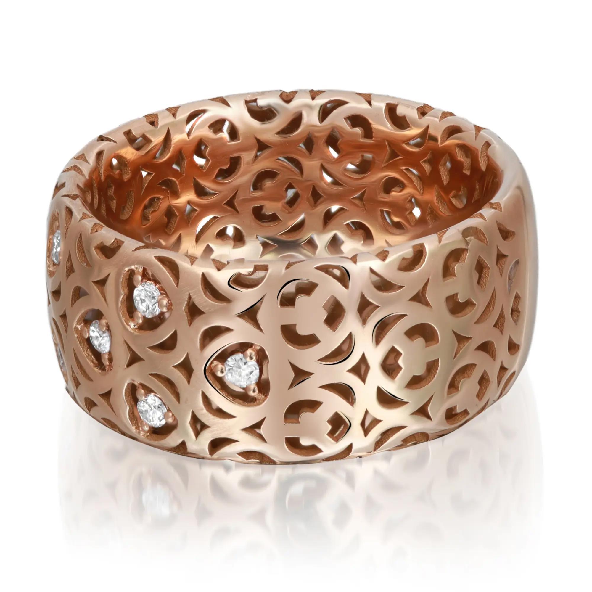 Modern ladies wide band ring crafted in 18k rose gold. This ring features an intricate cut out design studded with round cut diamonds in prong setting. Total diamond weight: 0.20 carat. Ring size: 6.5. Ring width: 9.7mm. Total weight: 7.07 grams. A