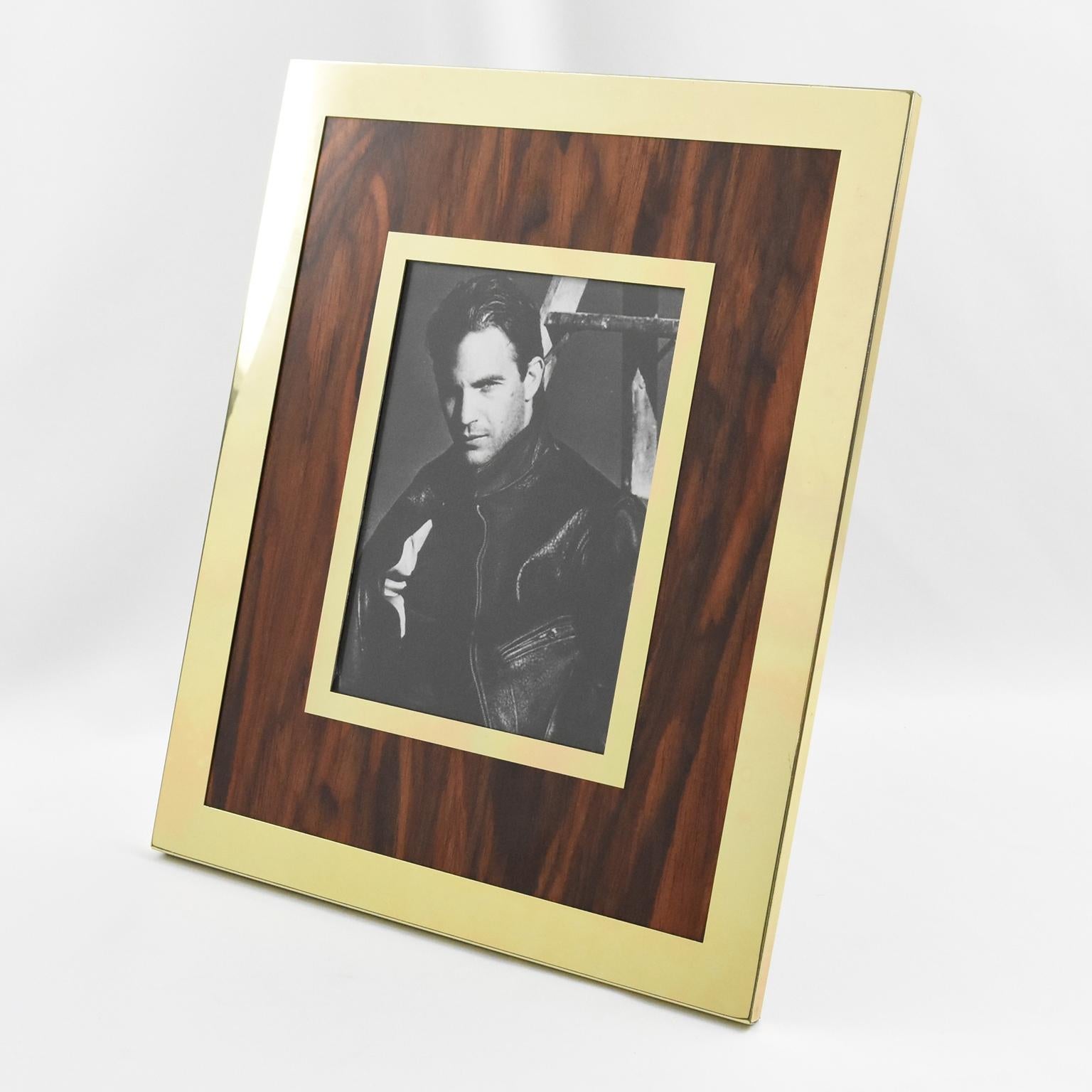 Italian designer Umberto Mascagni crafted this lovely picture photo frame in Bologna, Italy, in the 1970s. The frame features gilded aluminum and Formica flamed-walnut wood imitation. The frame has a metal easel at the back and is marked 