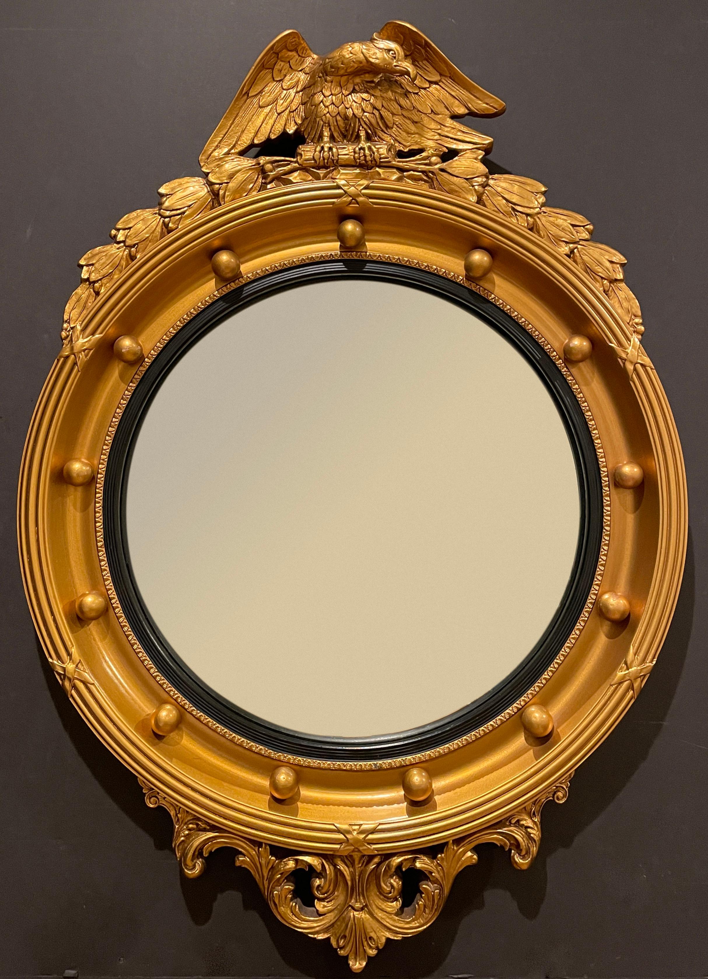Nicely modelled gilt American Federal style convex mirror with eagle at crest. Ball design and reeded black molding separating glass from frame.