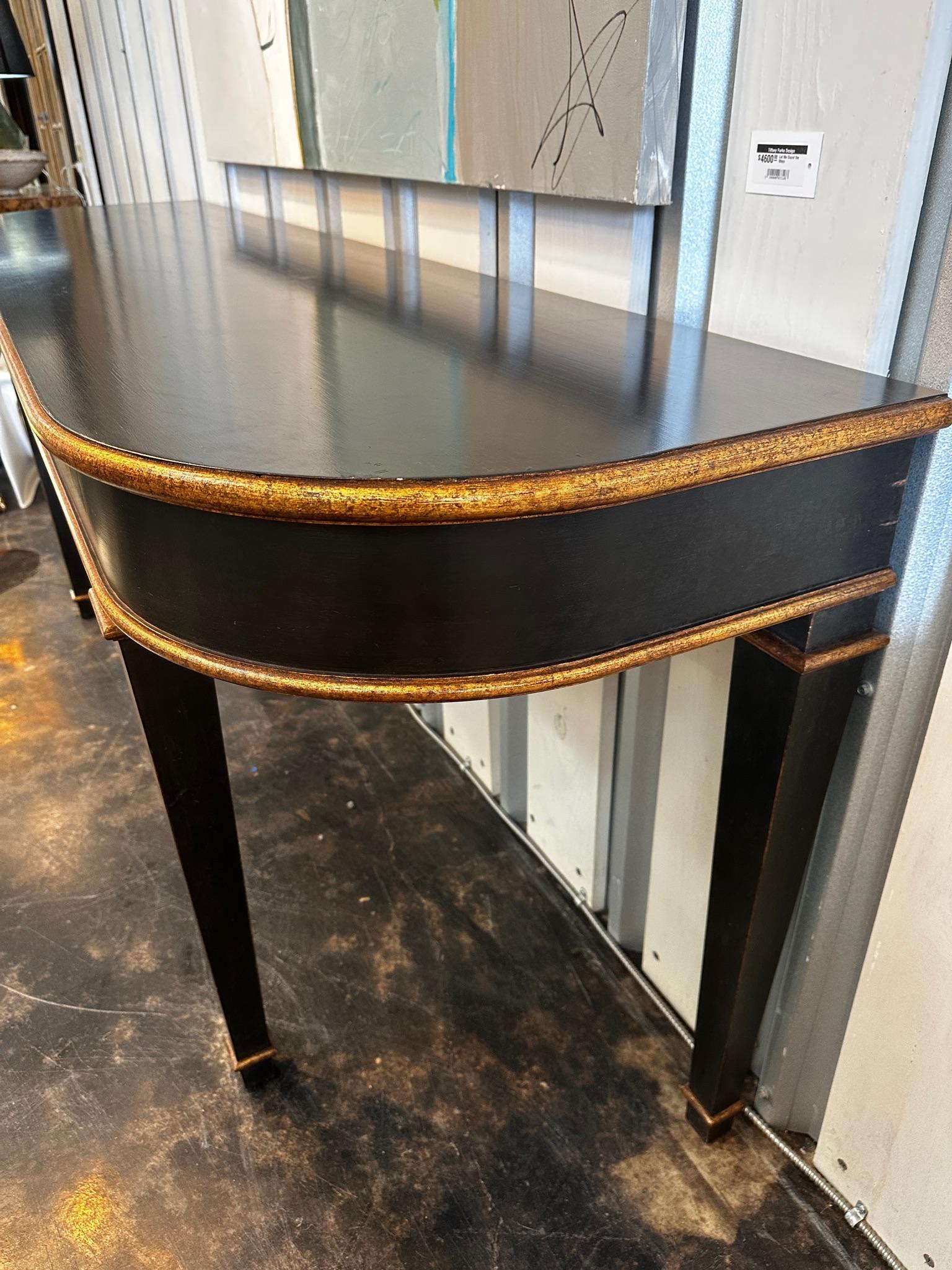 This beautiful and large custom console table with black lacquer finish and gilt details is stunning. Its simple form and finish make it a perfect fit in many decorative styles. Some may call it French, some may say Hepplewhite inspired. the