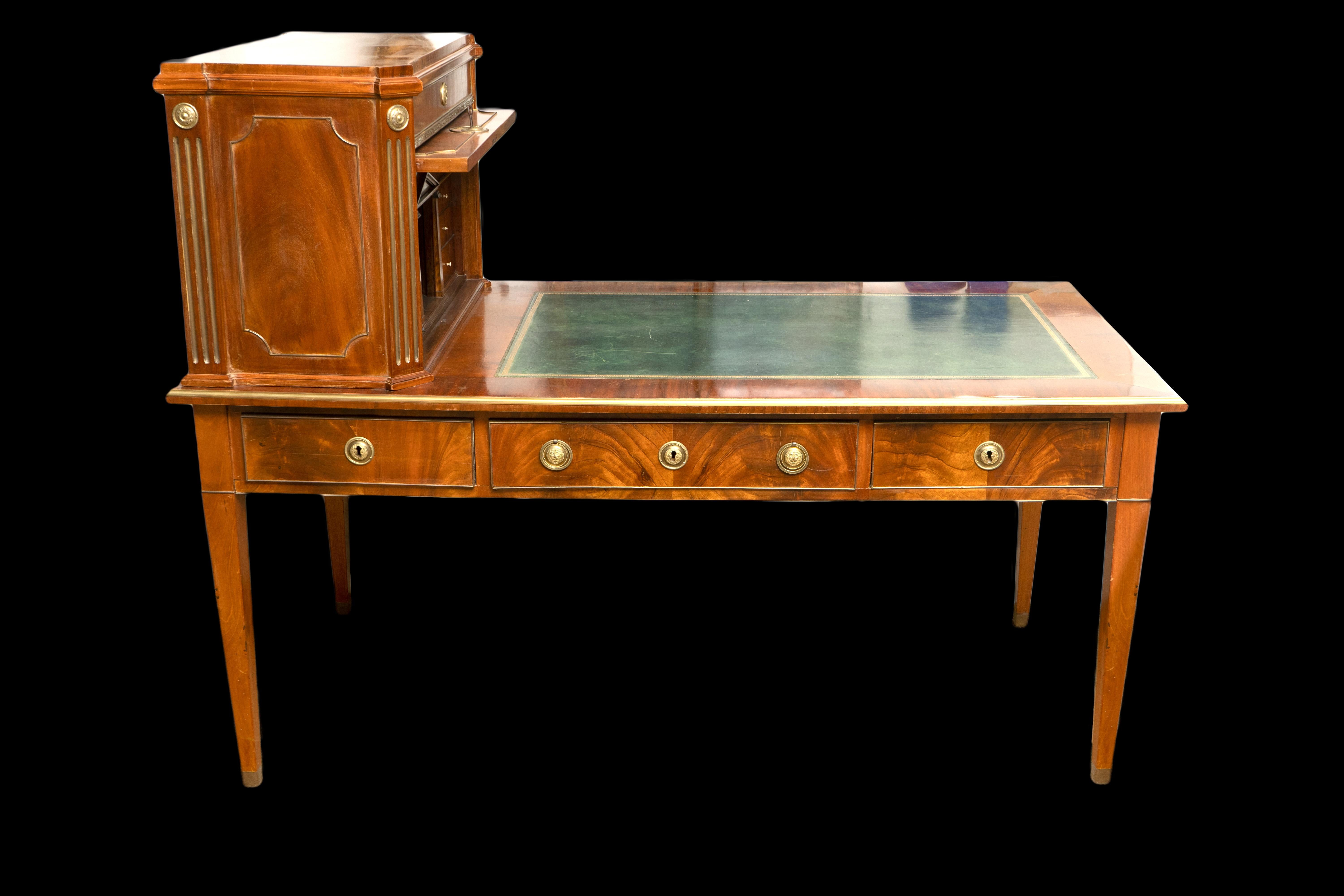 Dieser exquisite Schreibtisch ist ein wahres Meisterwerk der Handwerkskunst des neunzehnten Jahrhunderts. Der Schreibtisch ist aus reich gemasertem Mahagoni gefertigt und mit exquisiten Bronzebeschlägen verziert, die dem klassischen Design einen