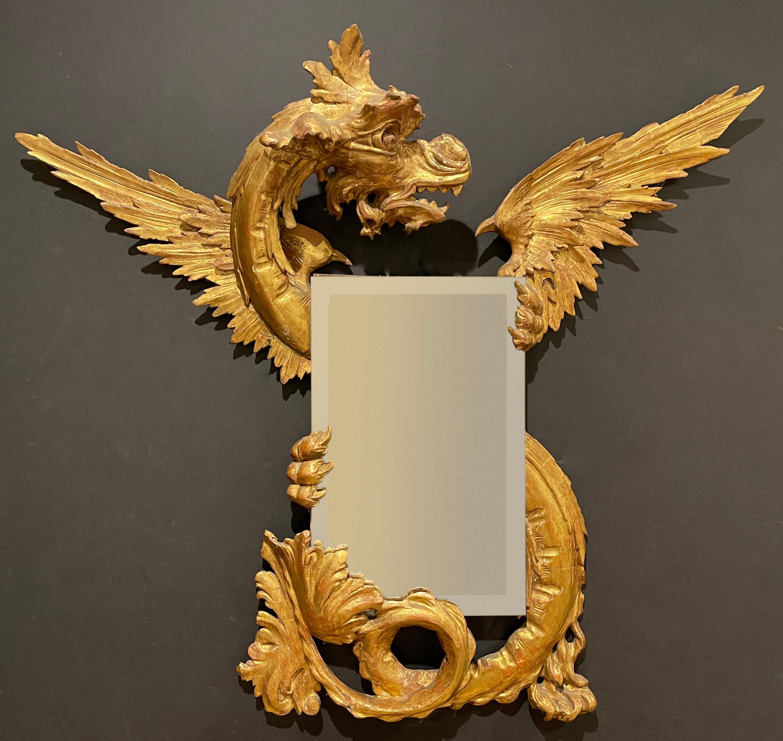 Miroir en forme de dragon merveilleusement sculpté et doré. Italie du Nord, 19e siècle, style Renaissance. Miroir biseauté tenu entre les mains/griffes et la queue
 