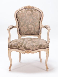 Gilt and painted French upholstered open armchair in the Louis XV style.