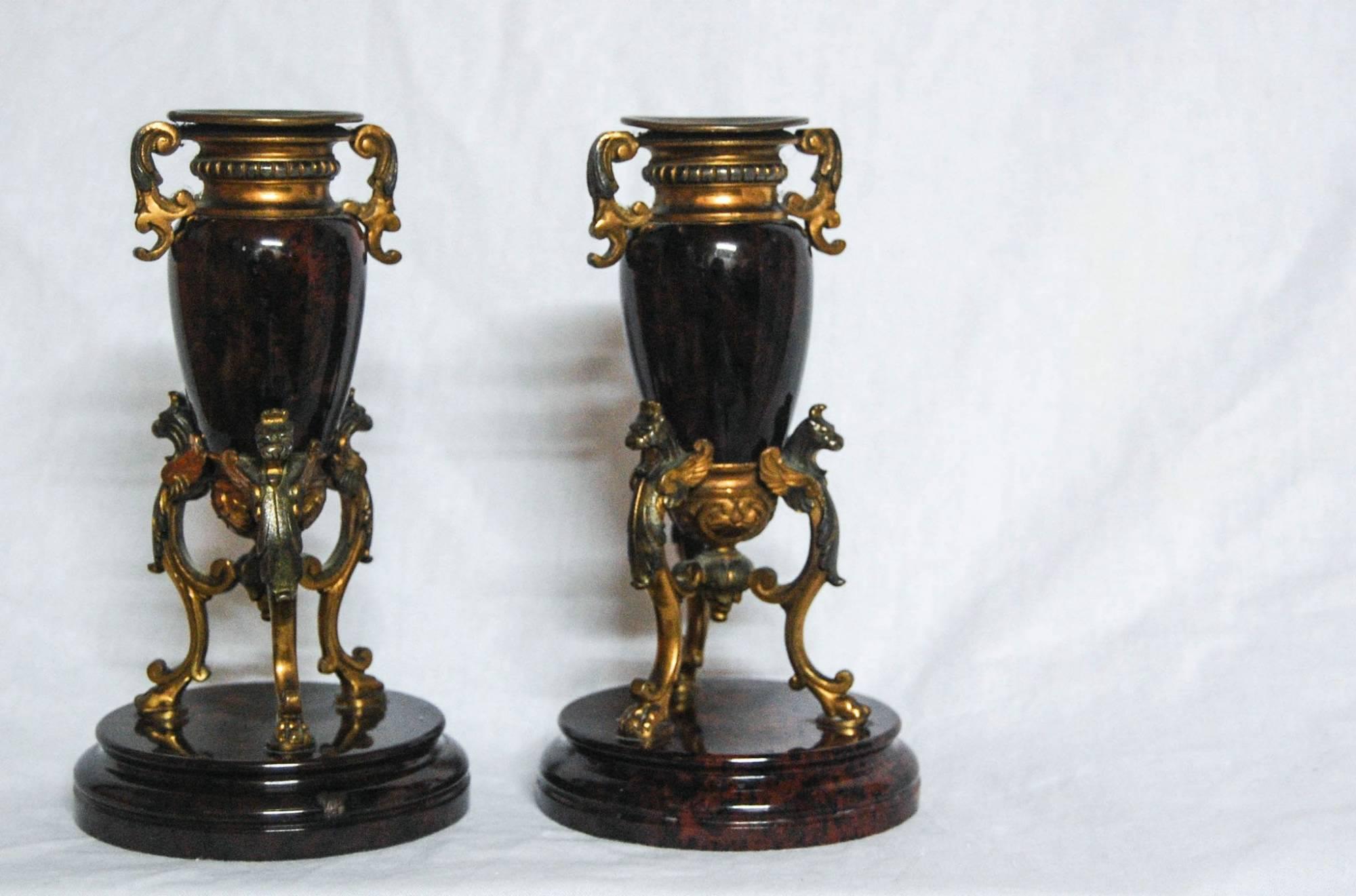 A superb pair of early Victorian serpentine and gilt metal candlestick holders.

The candle holders are comprised of a solid circular serpentine base with three fire gilt metal struts in the form of winged lions holding a classical serpentine urn