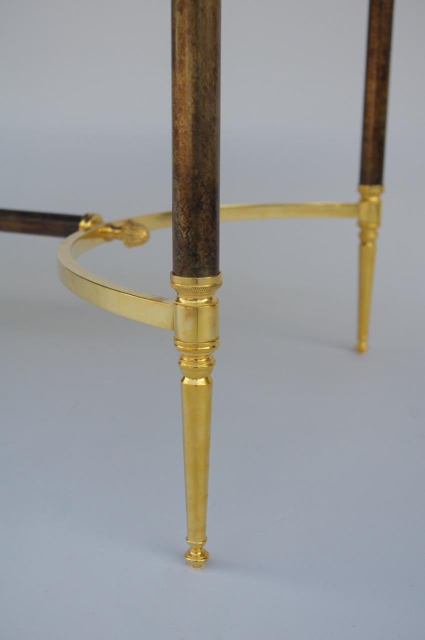 Rectangular gilt and silvered metal coffee table with an oxidized mirror top.
Palm capitals on the edges of the table and the H-shaped stretcher.
Design from Maison Jansen.
Work made circa 1970.