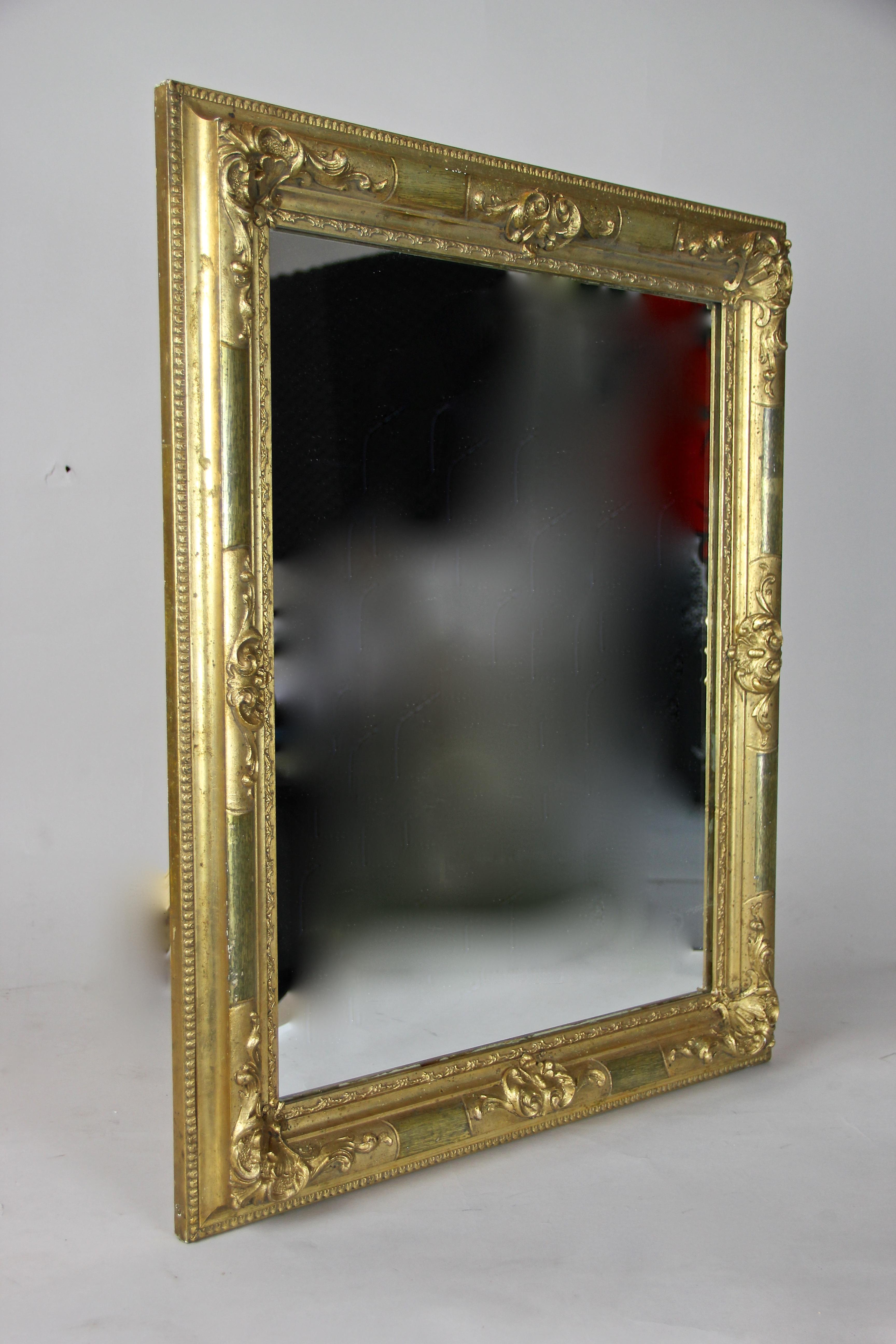 Remarkable gilt Biedermeier wall mirror from the later era circa 1850 in Austria. Nearly 170 year old, this great antique mirror was minimal restored by taking greatest care to keep its unique character. Only the mirror glass had to be renewed. The
